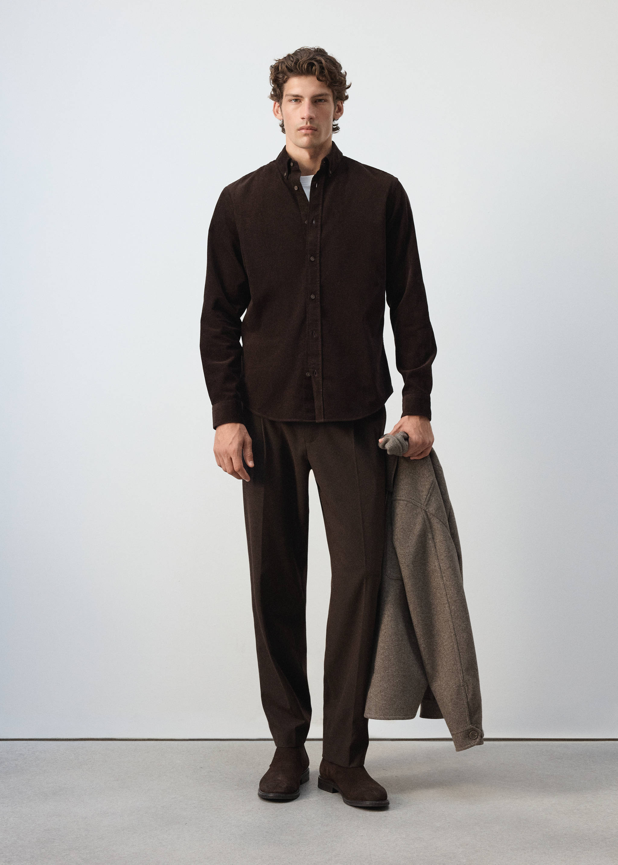 Dark brown corduroy shirt with long sleeves worn with matching trousers.