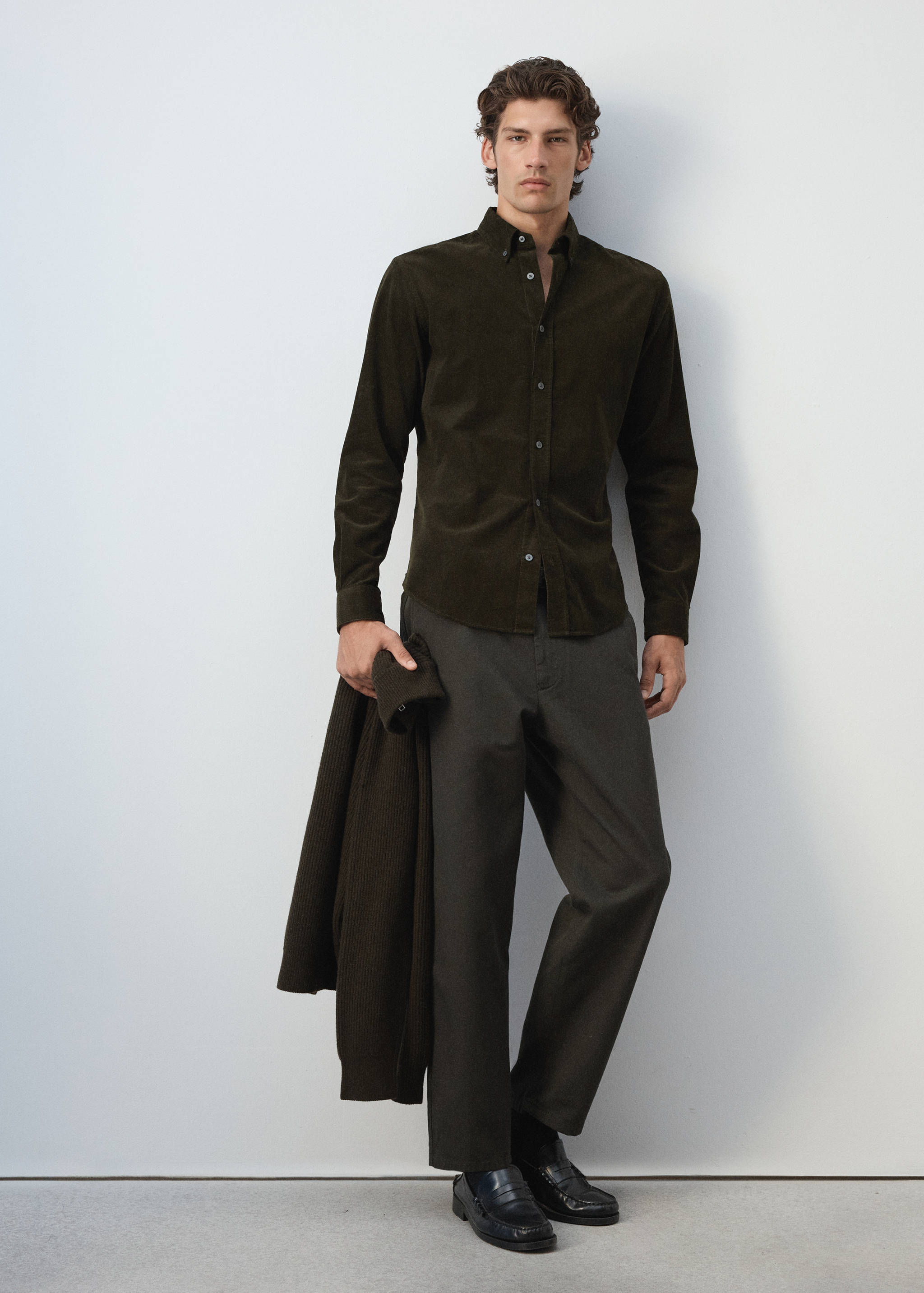 Dark green corduroy shirt with a button-down collar worn by a model.
