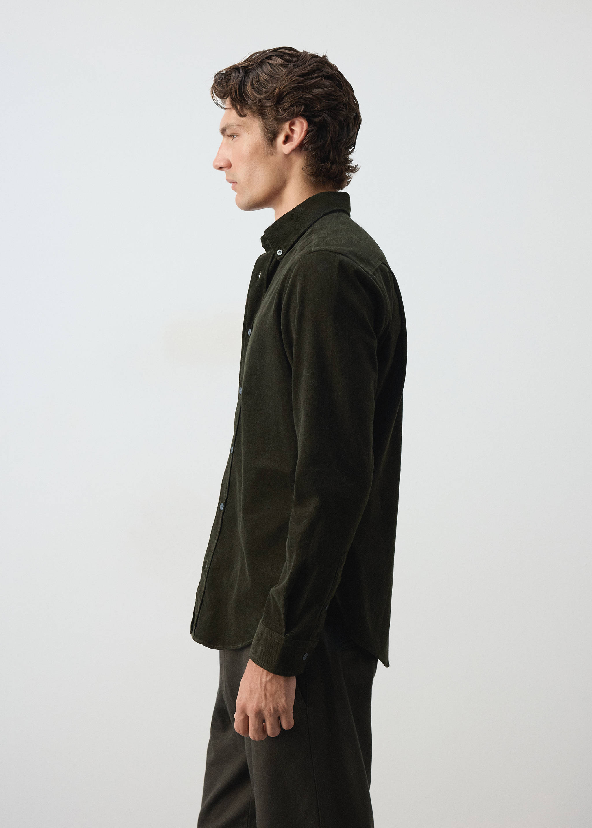 Dark green corduroy shirt with long sleeves and a button-down collar.
