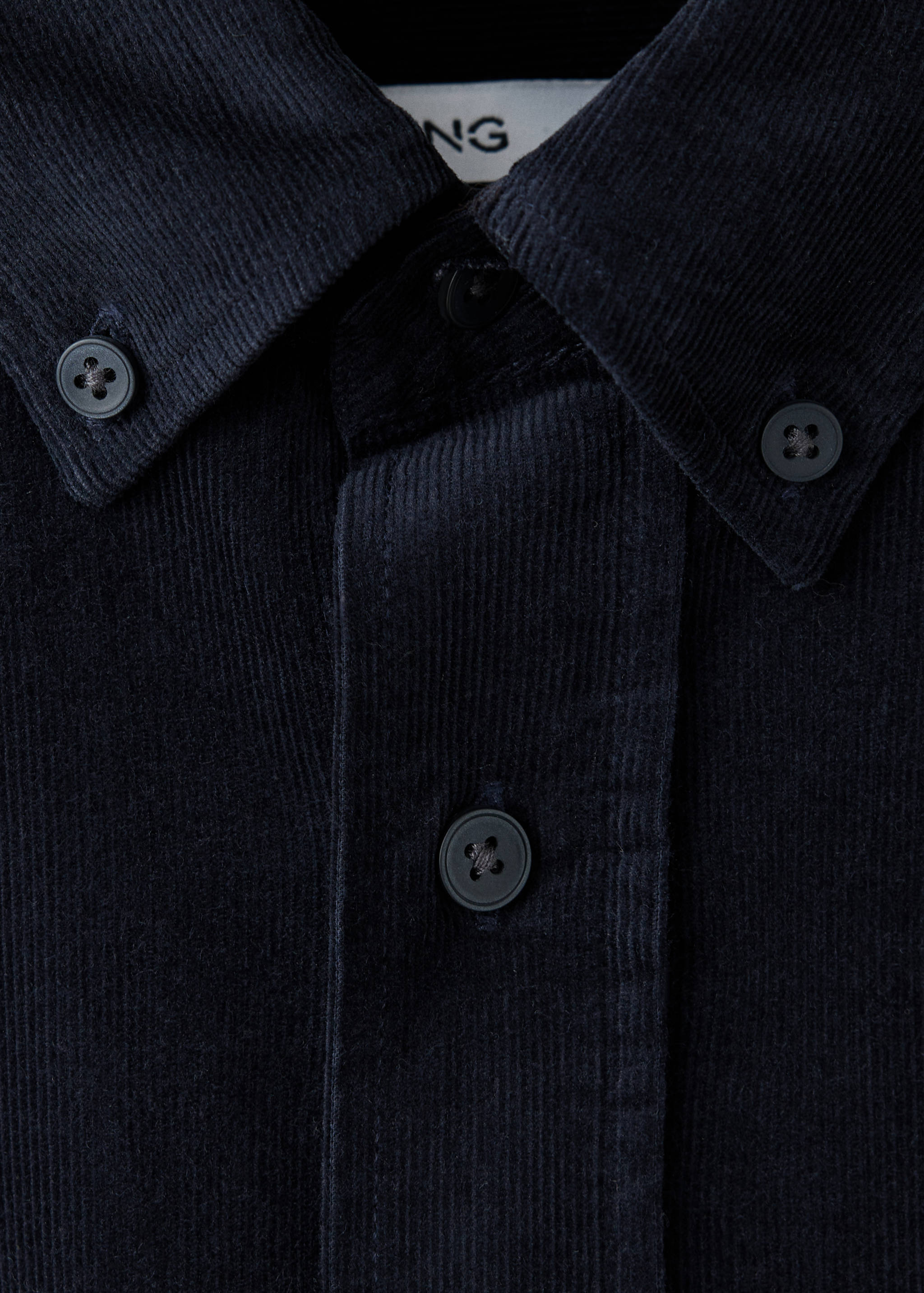 Dark navy blue corduroy shirt collar and buttoned placket detail.
