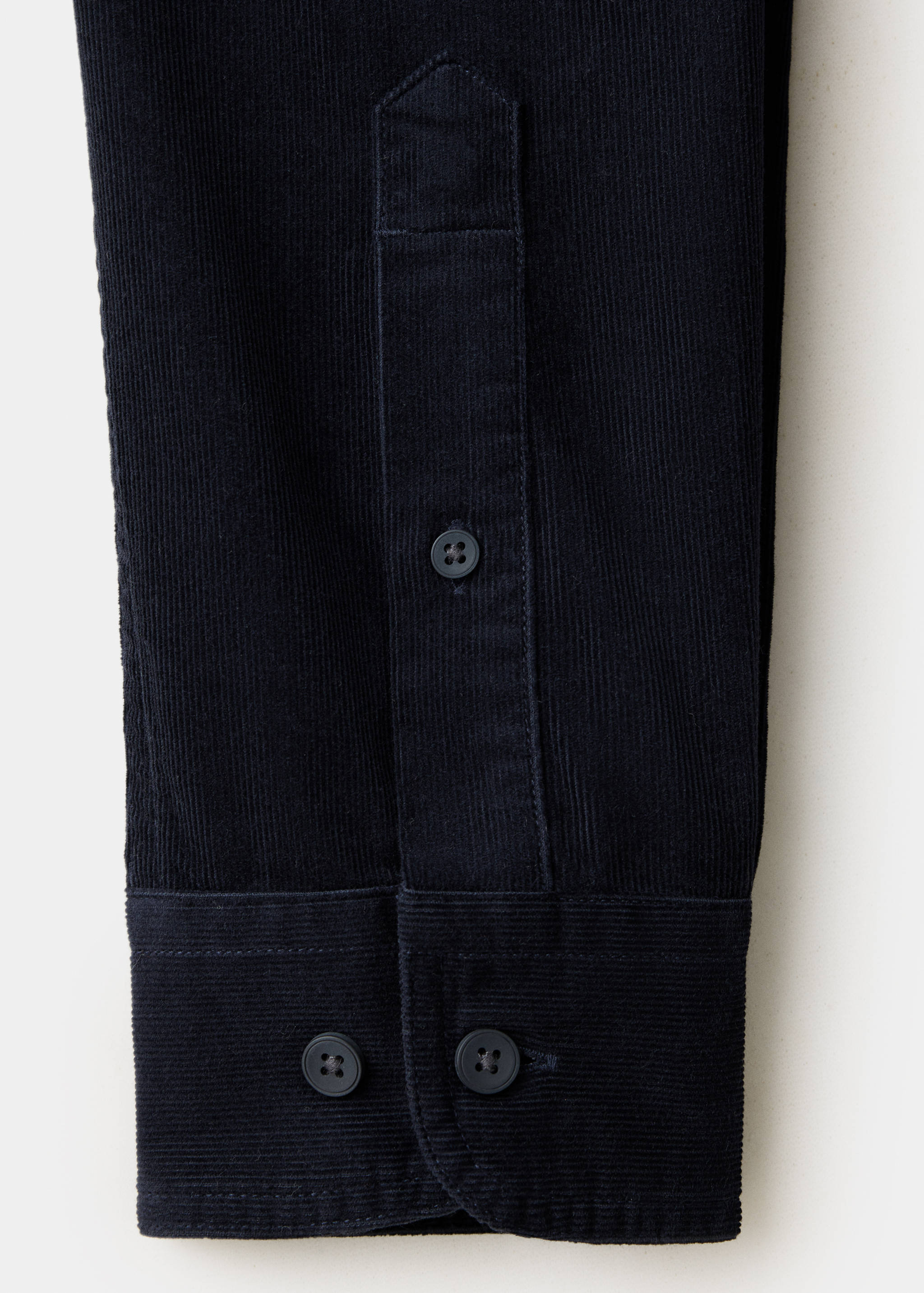 Navy blue corduroy shirt cuff detail showing matching buttons.