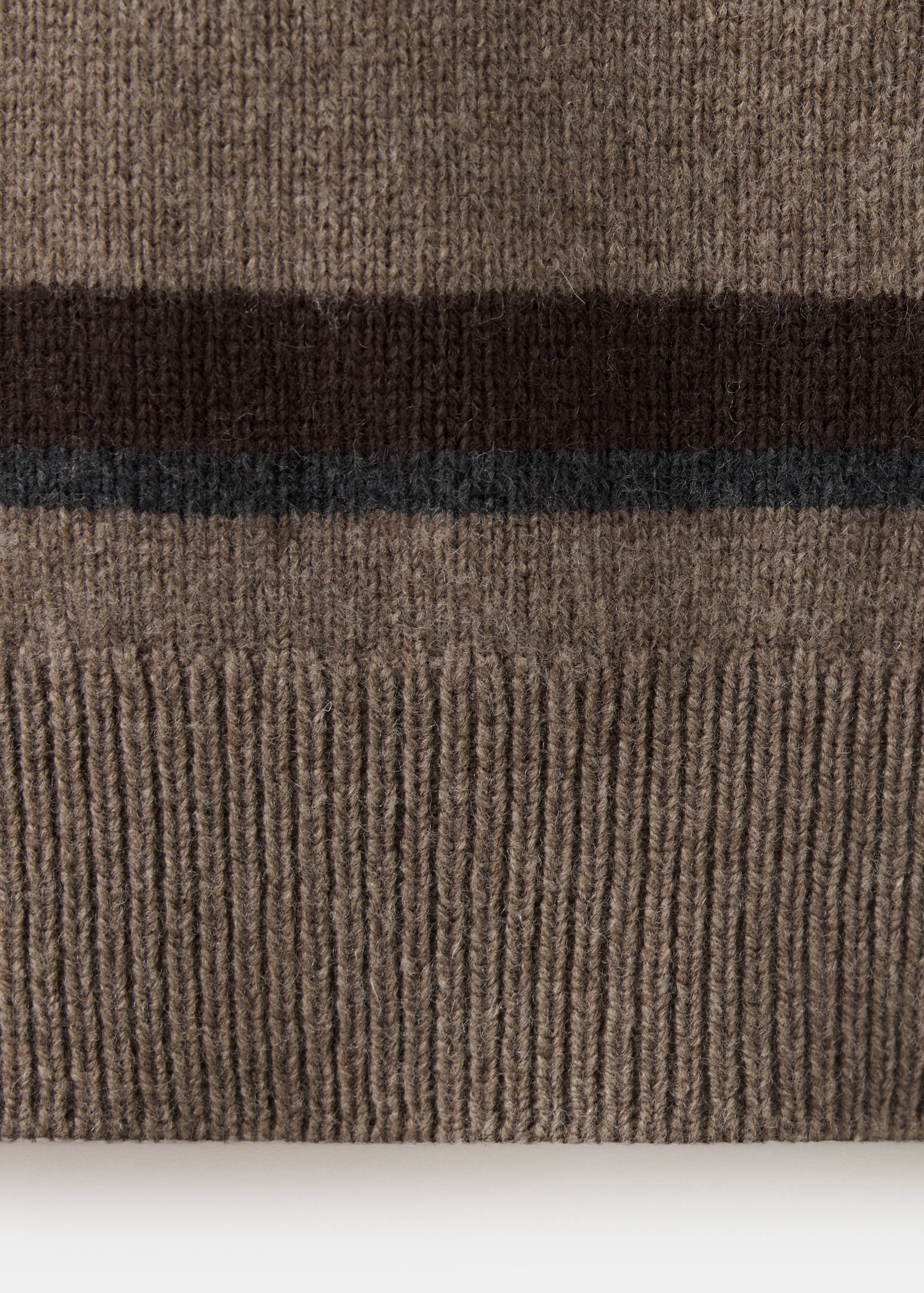 Close-up of ribbed knit fabric on a brown polo shirt with horizontal stripes.