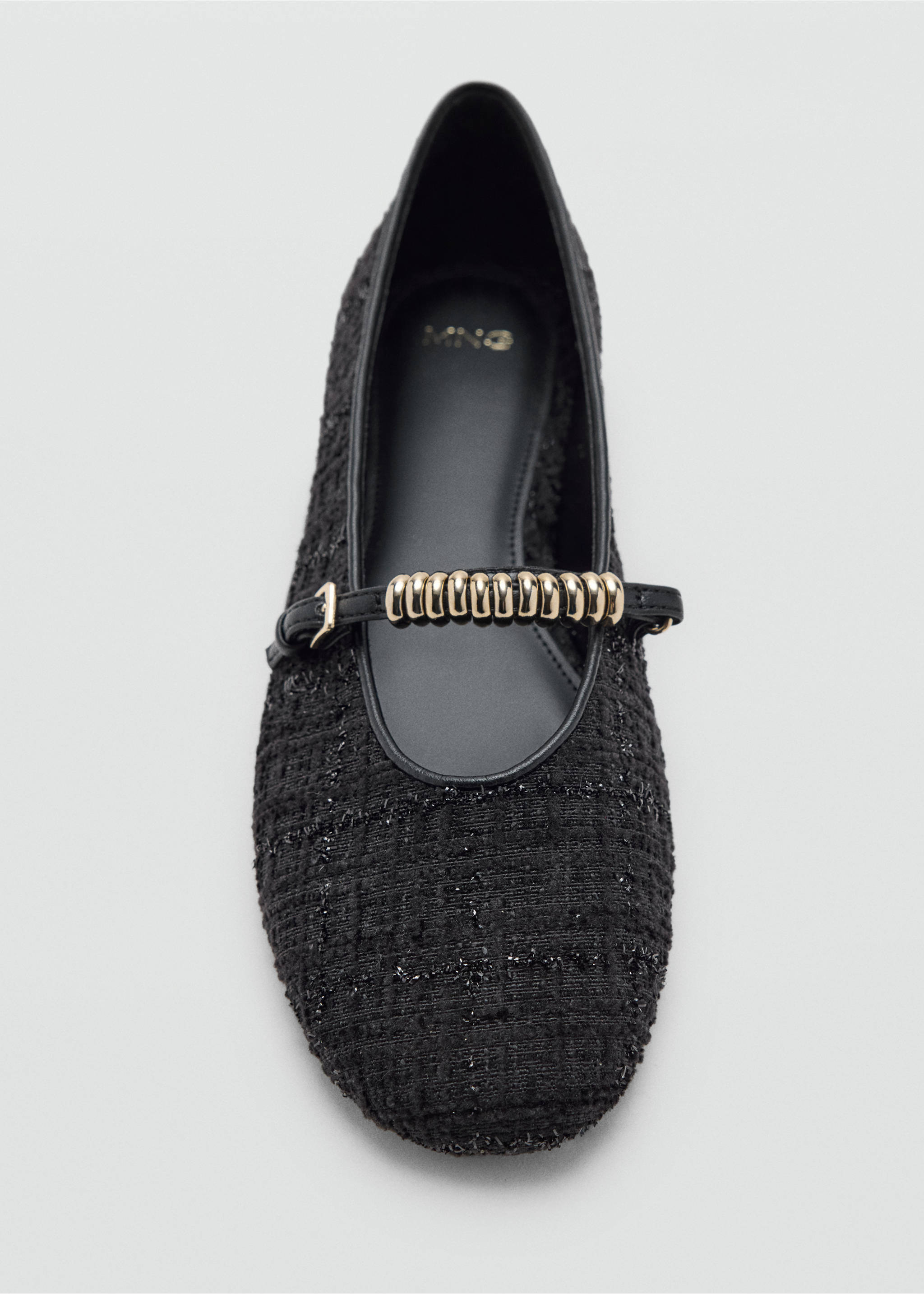 Black textured shoe with a rounded toe and metallic gold instep strap detail., Black. Ref: 37087910-00.