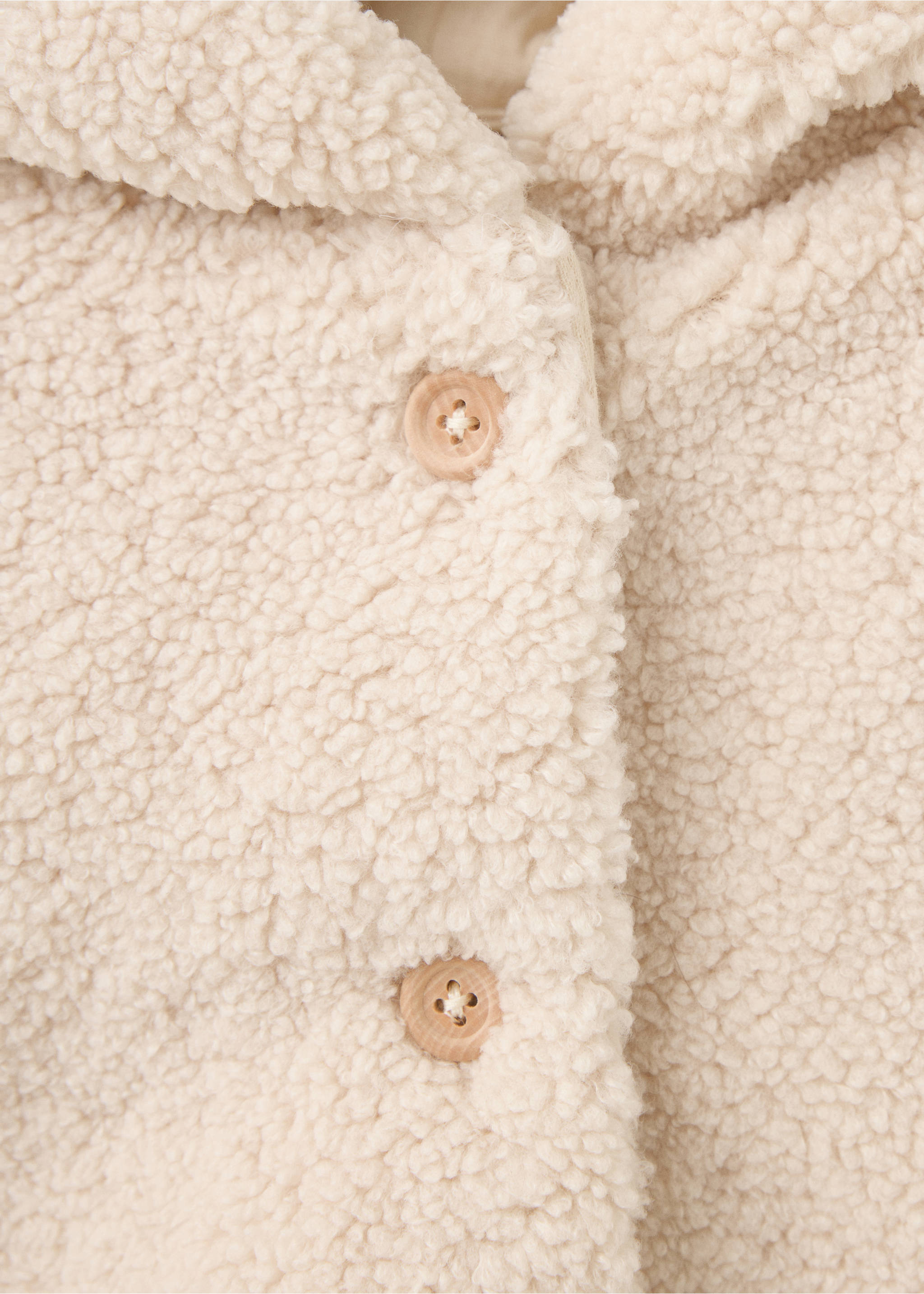 Close-up of an off-white shearling coat with wooden buttons., Ecru. Ref: 37087917-00.