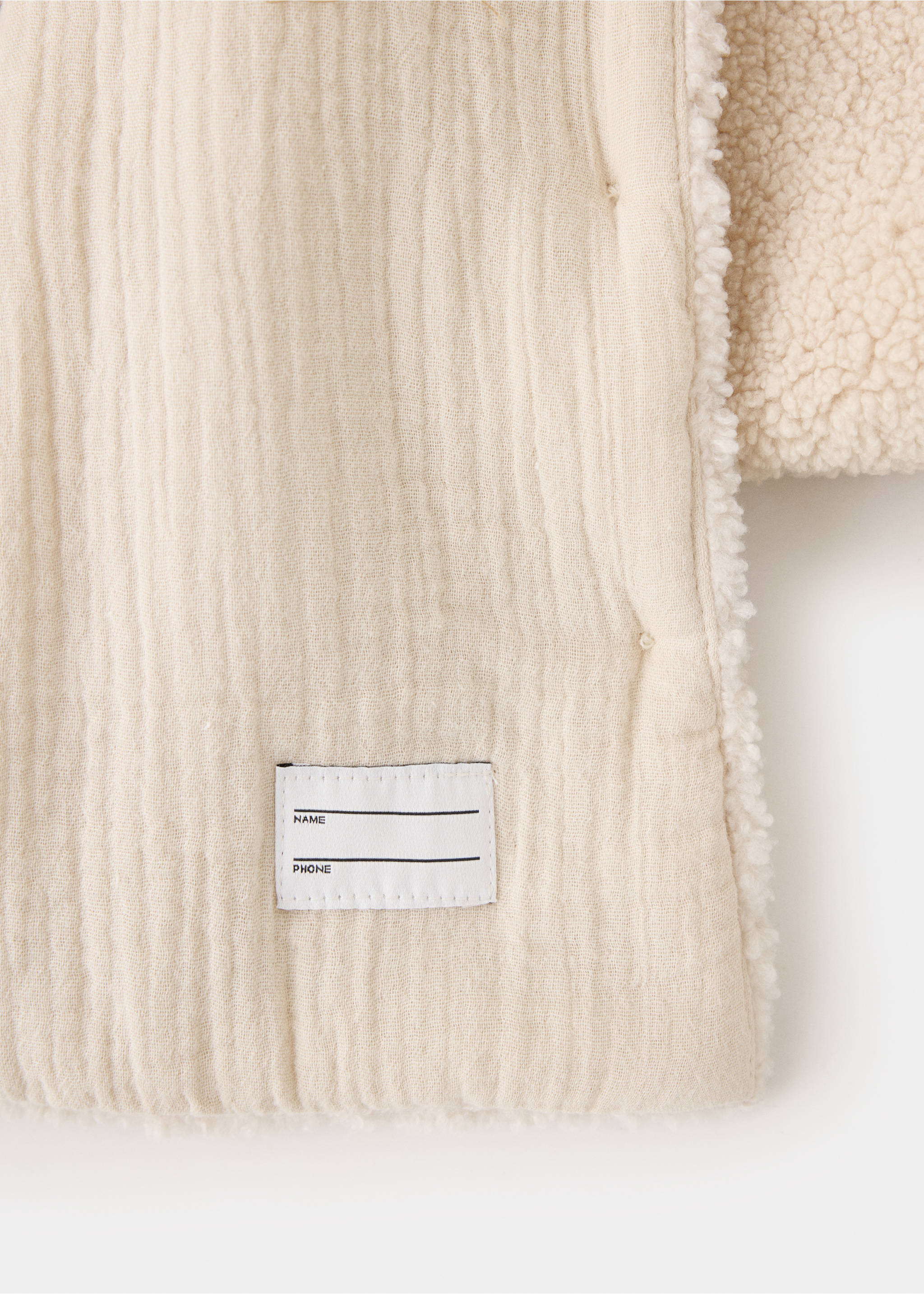Close-up of the textured cotton and faux-shearling lining of a cream kids coat., Ecru. Ref: 37087917-00.