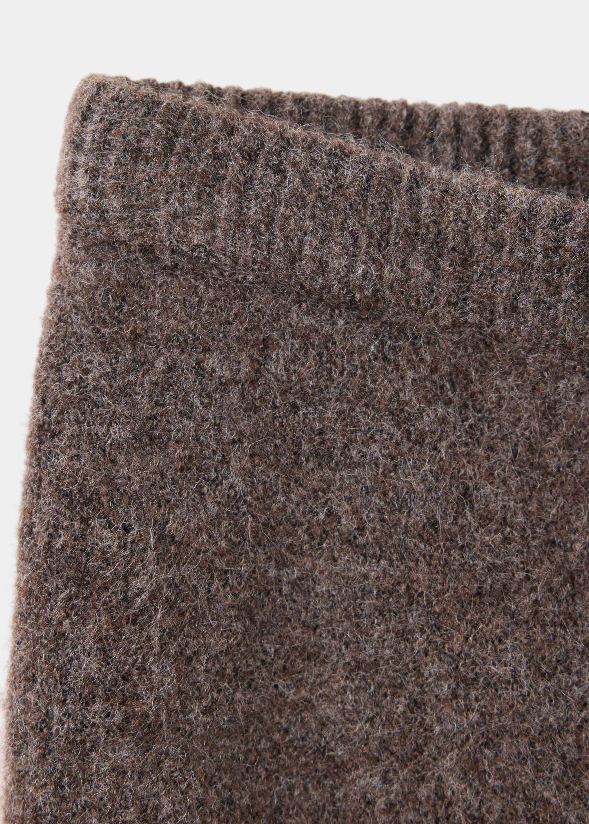 Detalle de la cintura de los pantalones de punto marrones.