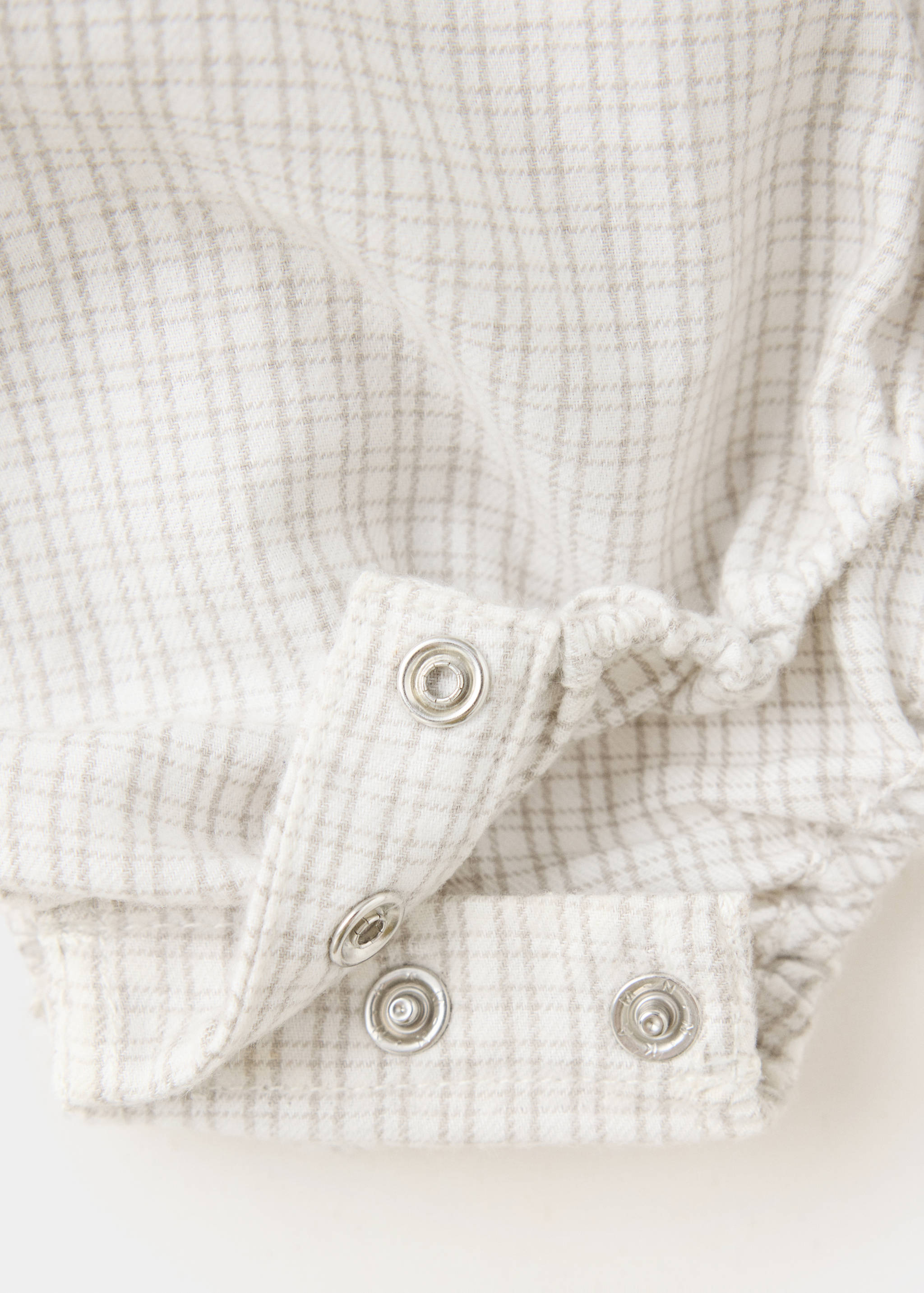 Checkered shirt fabric detail with snap-button closure