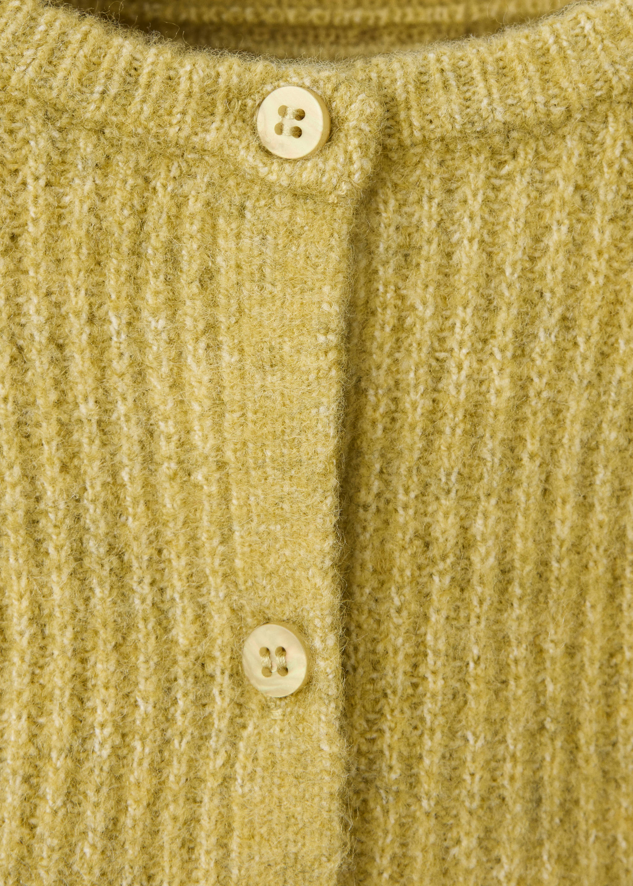 Close-up of a yellow ribbed knit cardigan with button fastening.