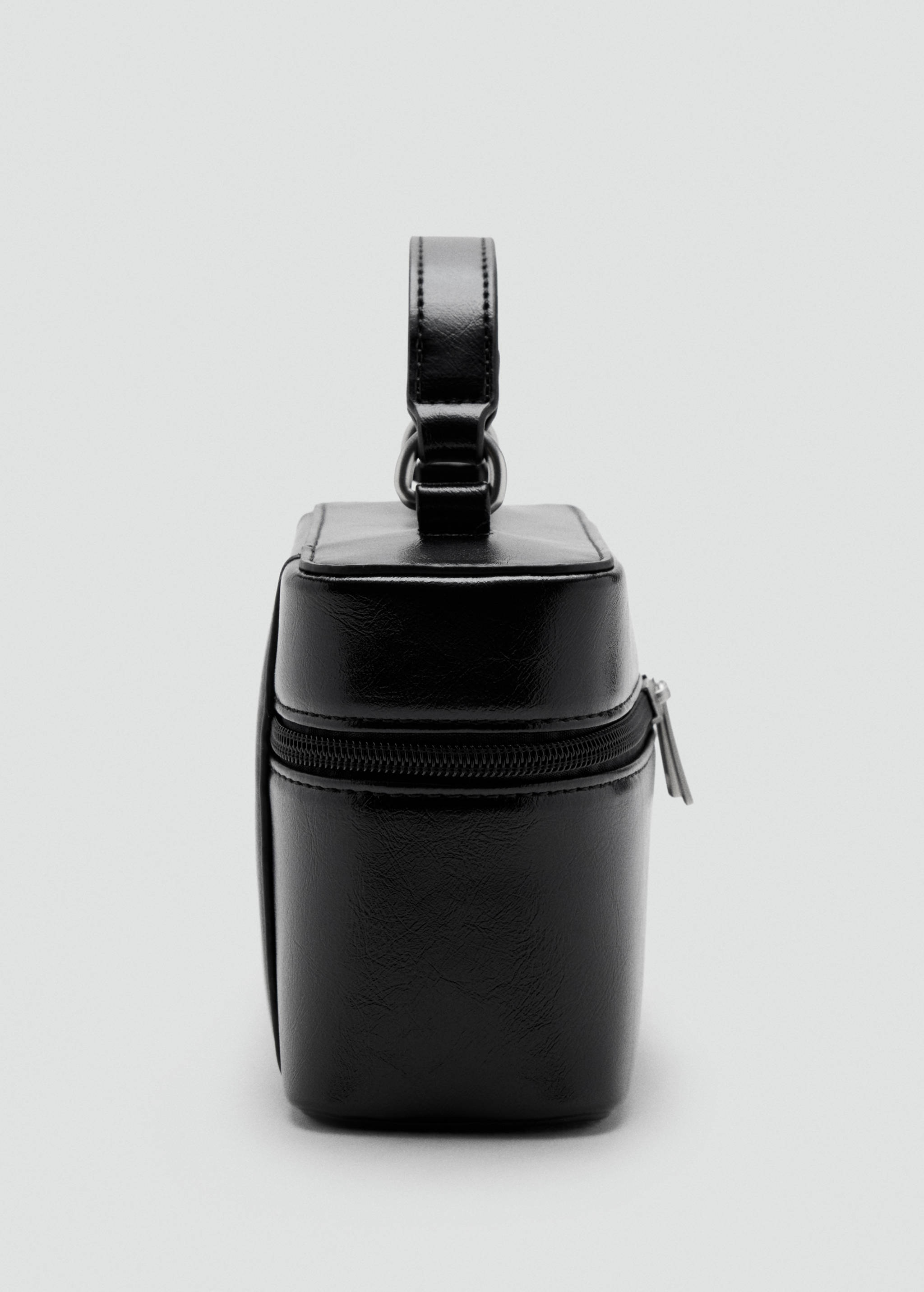 Black structured mini bag with top handle and zip fastening.
