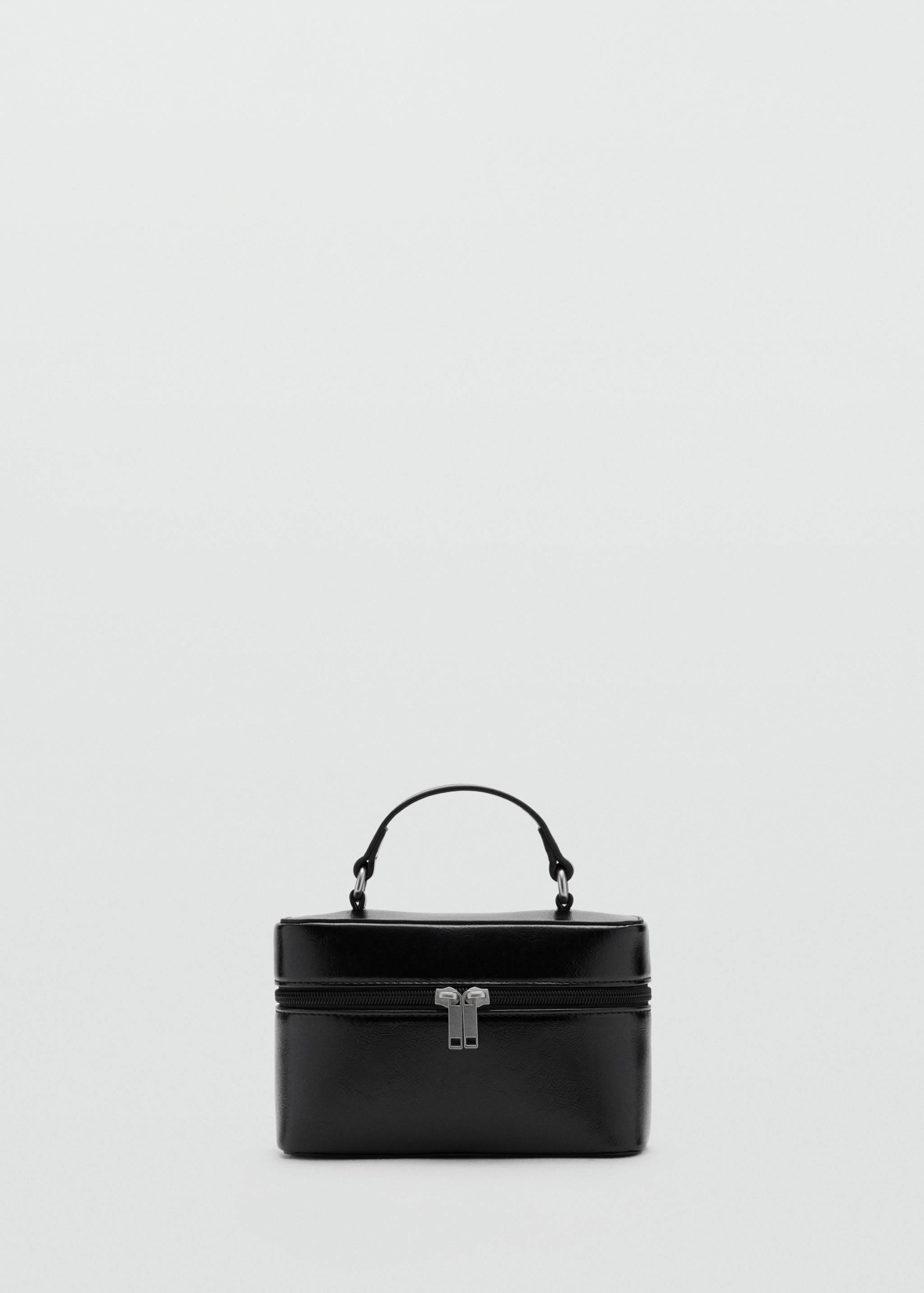 Black structured mini vanity bag with a top handle and silver-tone zip closure.