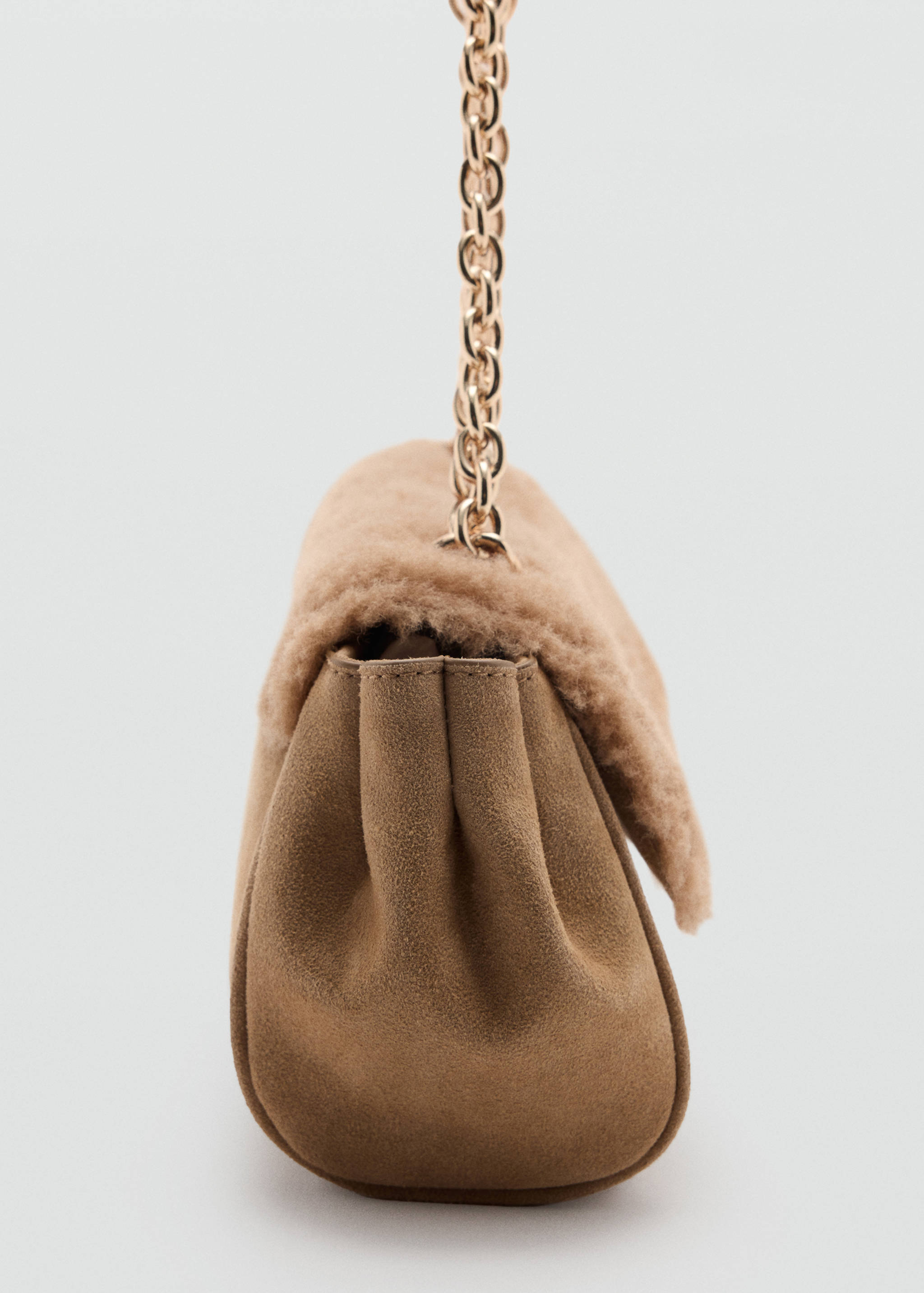 Camel brown shoulder bag with a faux-shearling flap, suede gussets, and a chain strap.