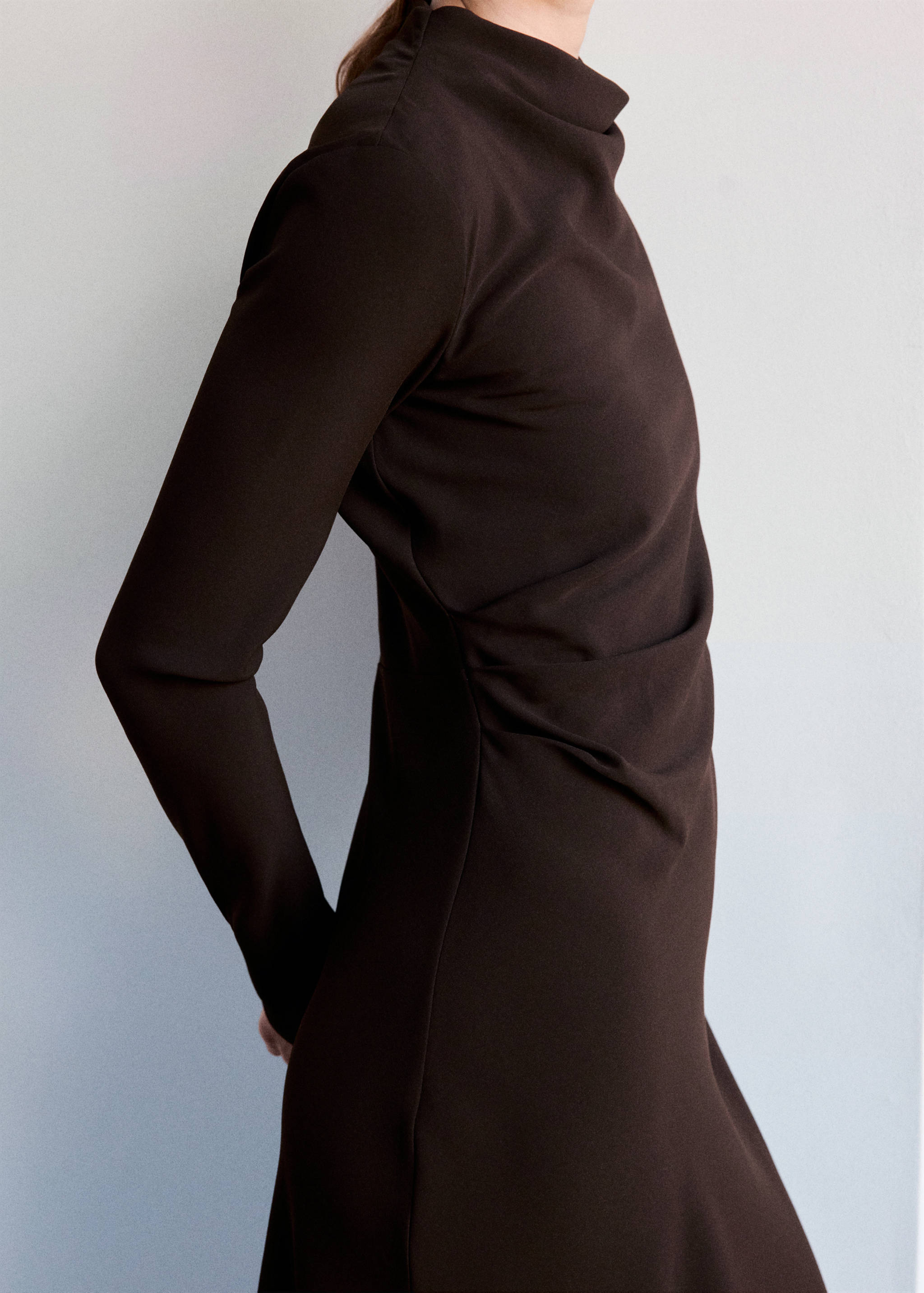 Vestido largo marrón oscuro de manga larga con cuello alto drapeado y diseño entallado.
