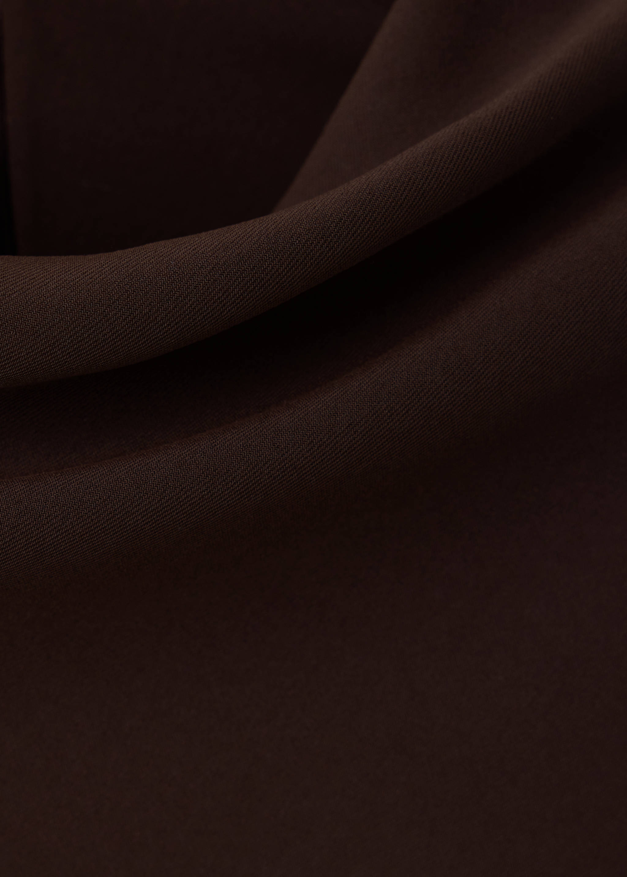 Primer plano de la textura de tejido marrón oscuro para un vestido.