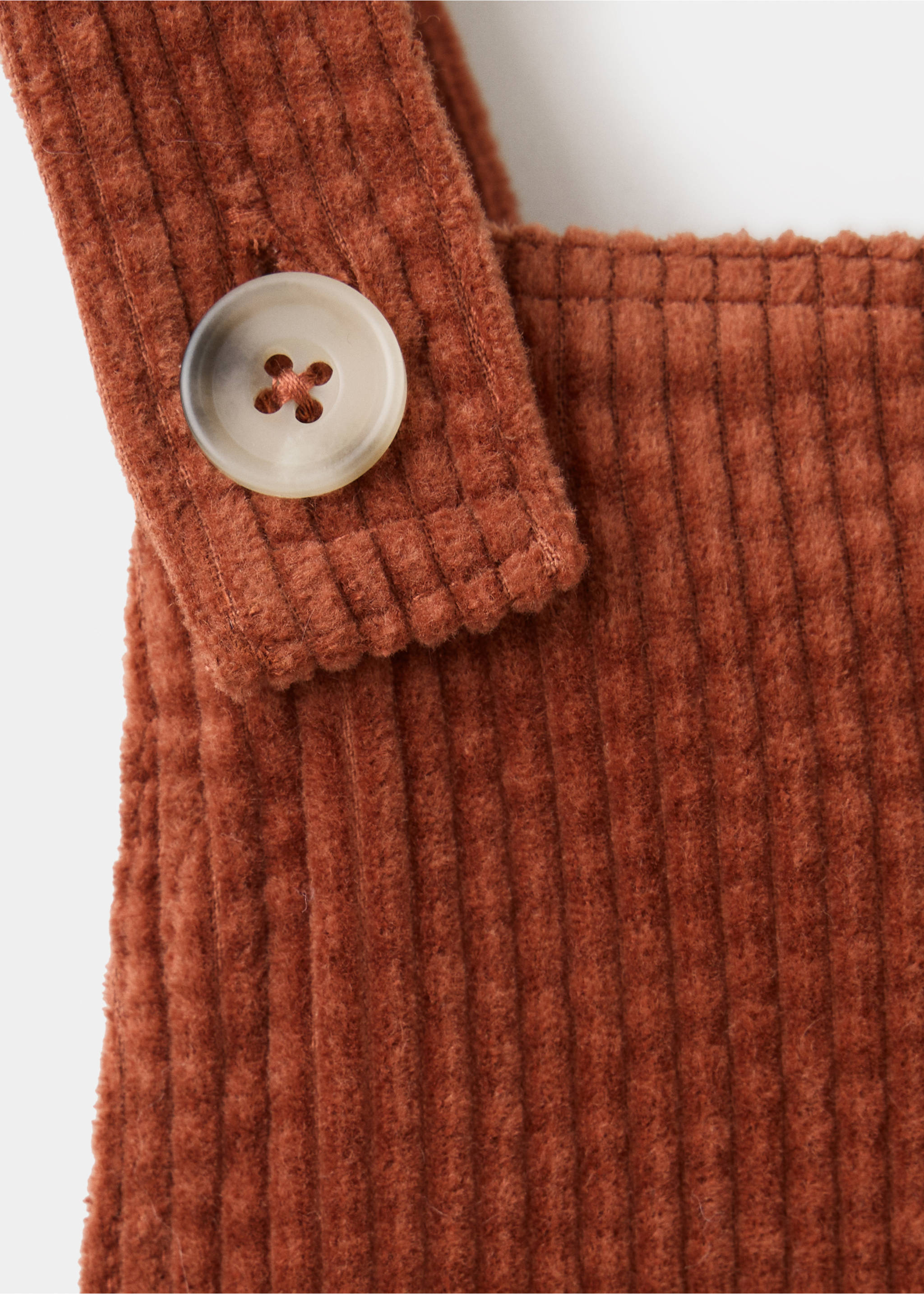 Close-up of rust-brown corduroy pinafore strap and button detail., Russet. Ref: 37088270-00.