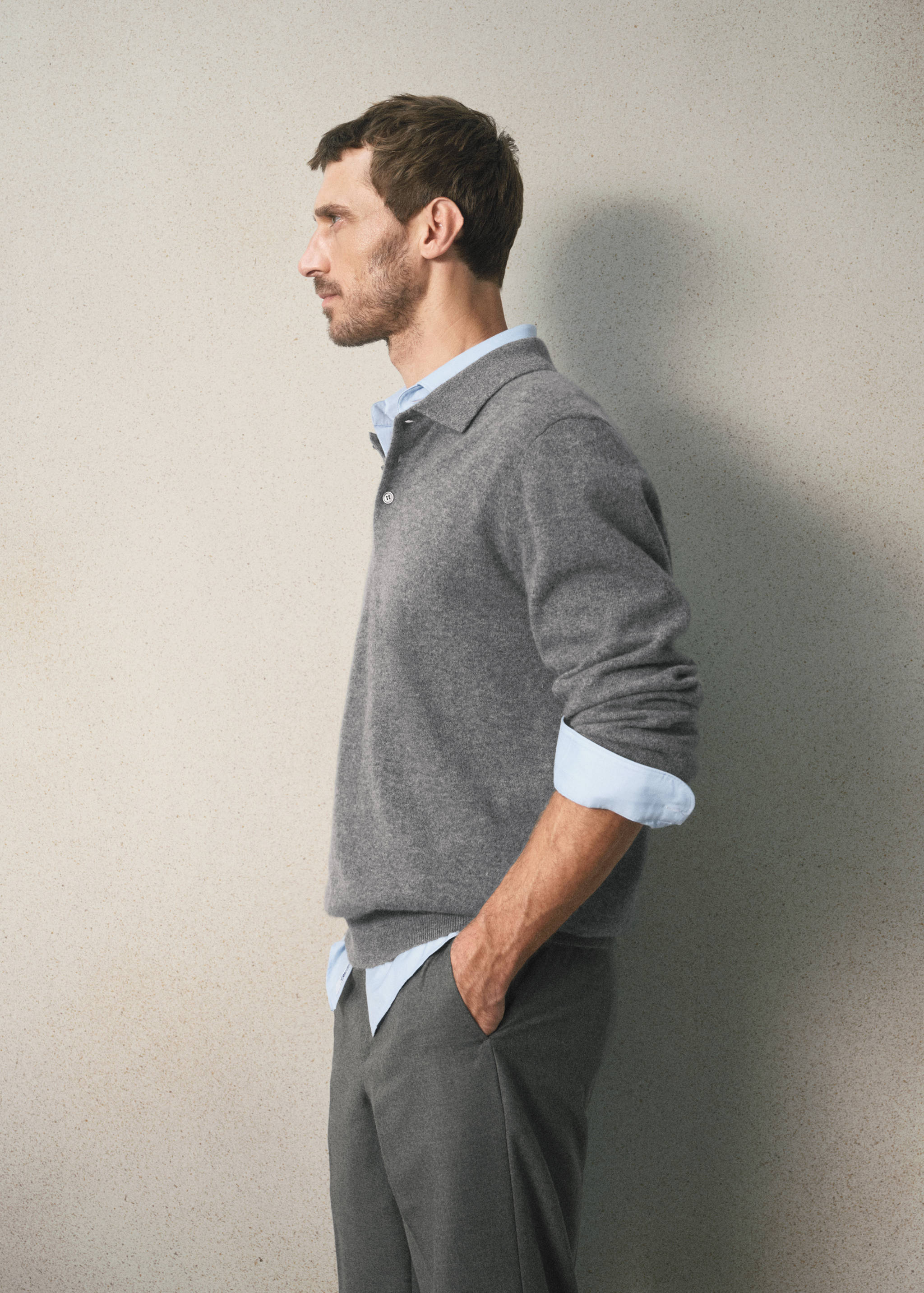 Grey knit polo layered over a light blue shirt