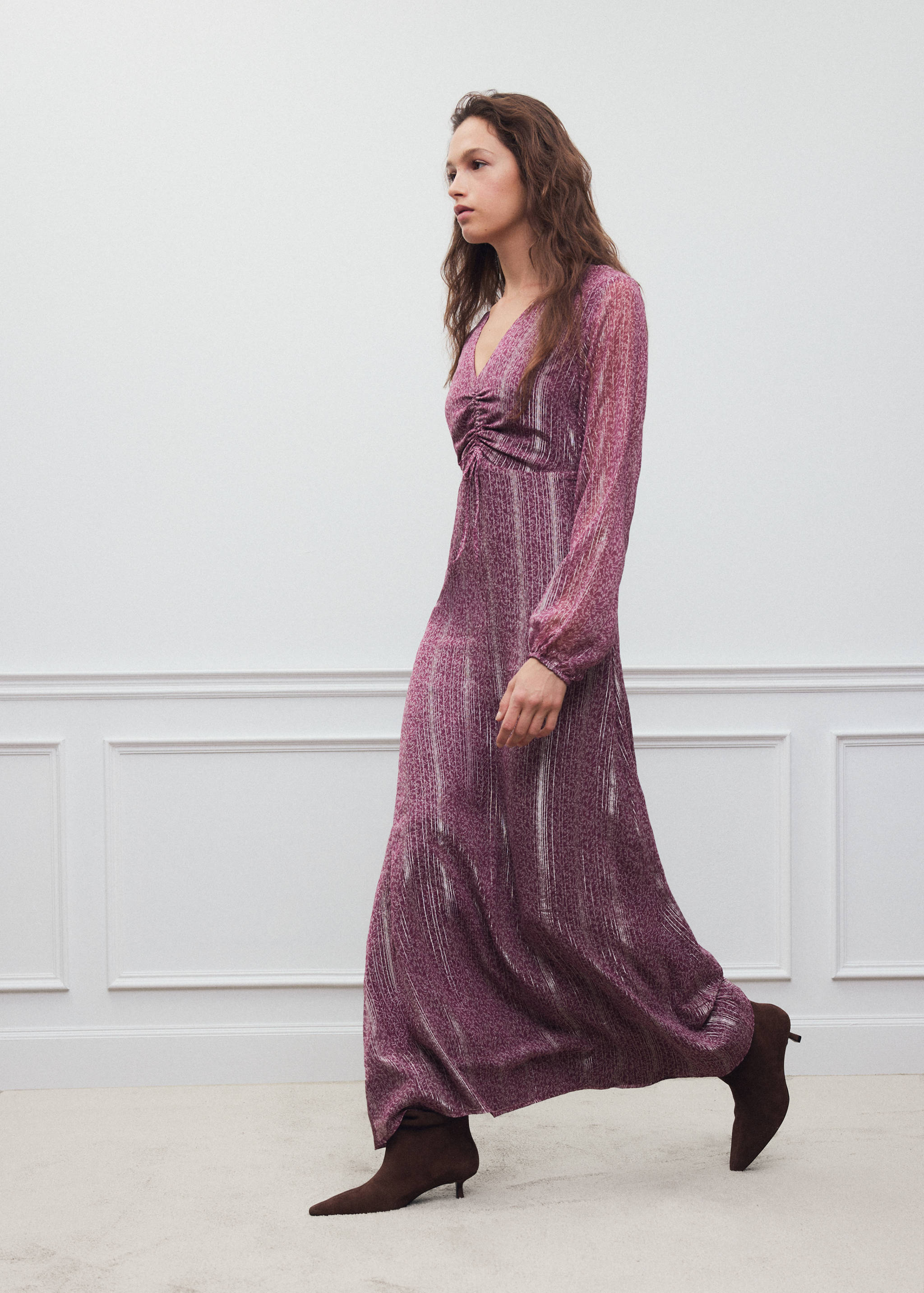 Vestido maxi rosa de manga larga con rayas verticales metalizadas y fruncidos.
