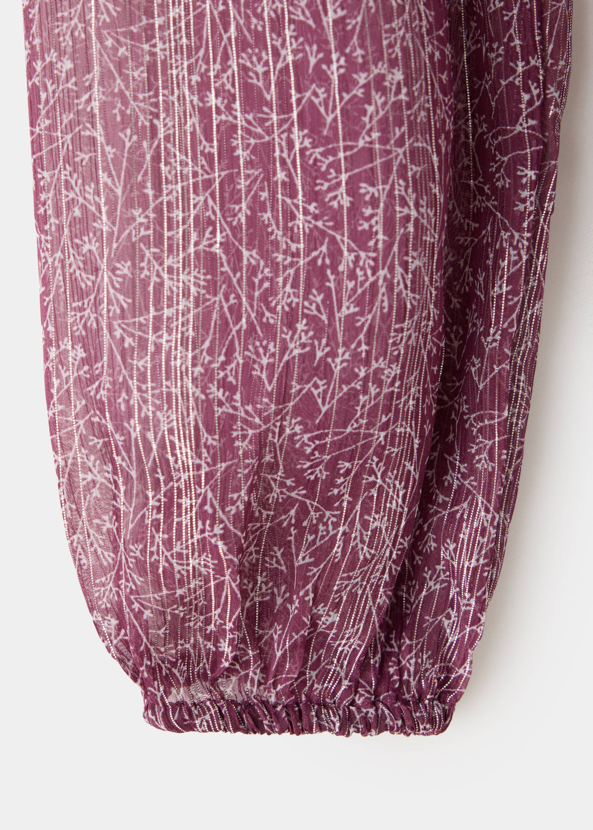 Detalle del tejido del vestido burdeos con estampado floral y rayas metalizadas