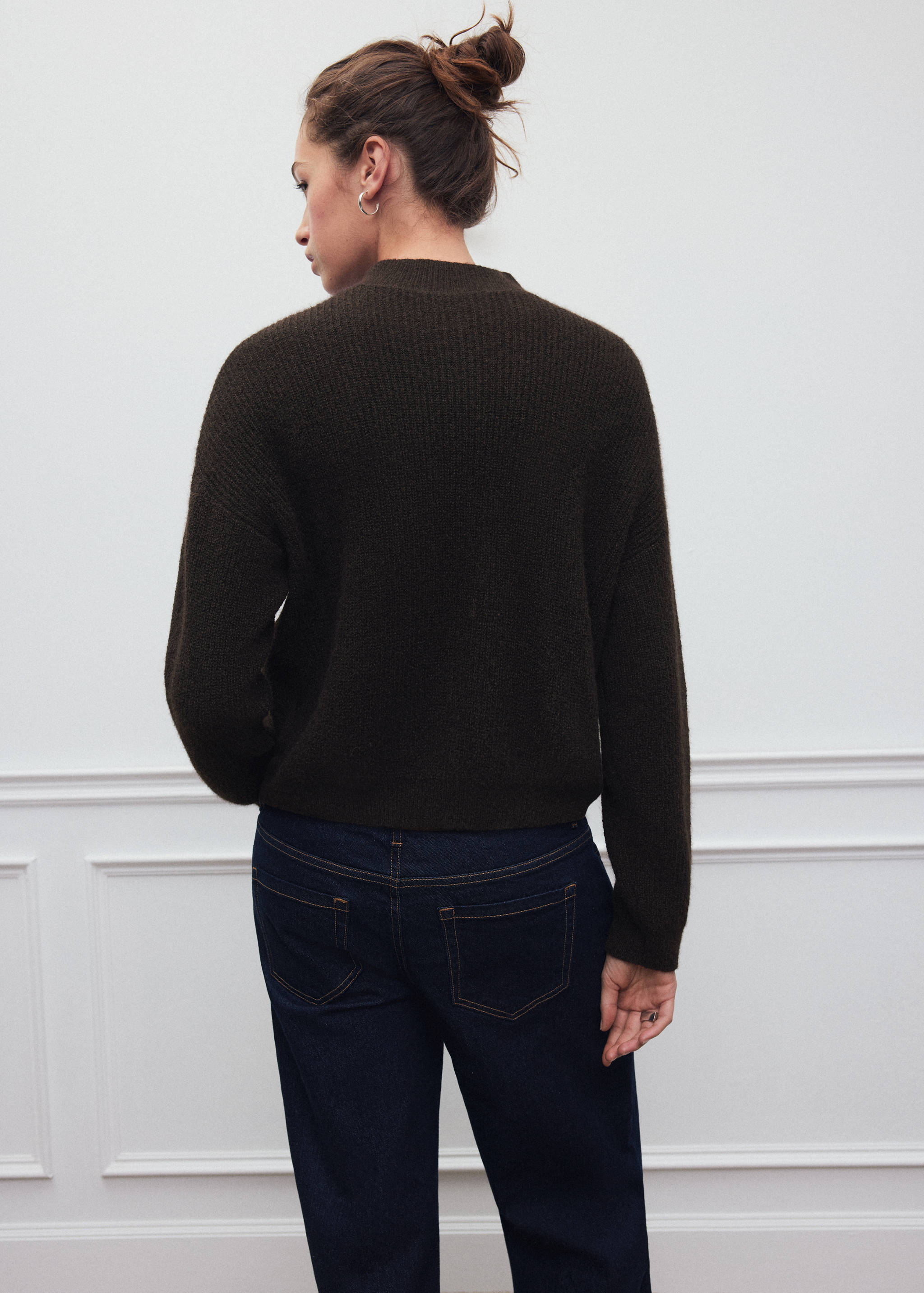Dark green knitted cardigan shown from the back, featuring a mock neck and ribbed texture.