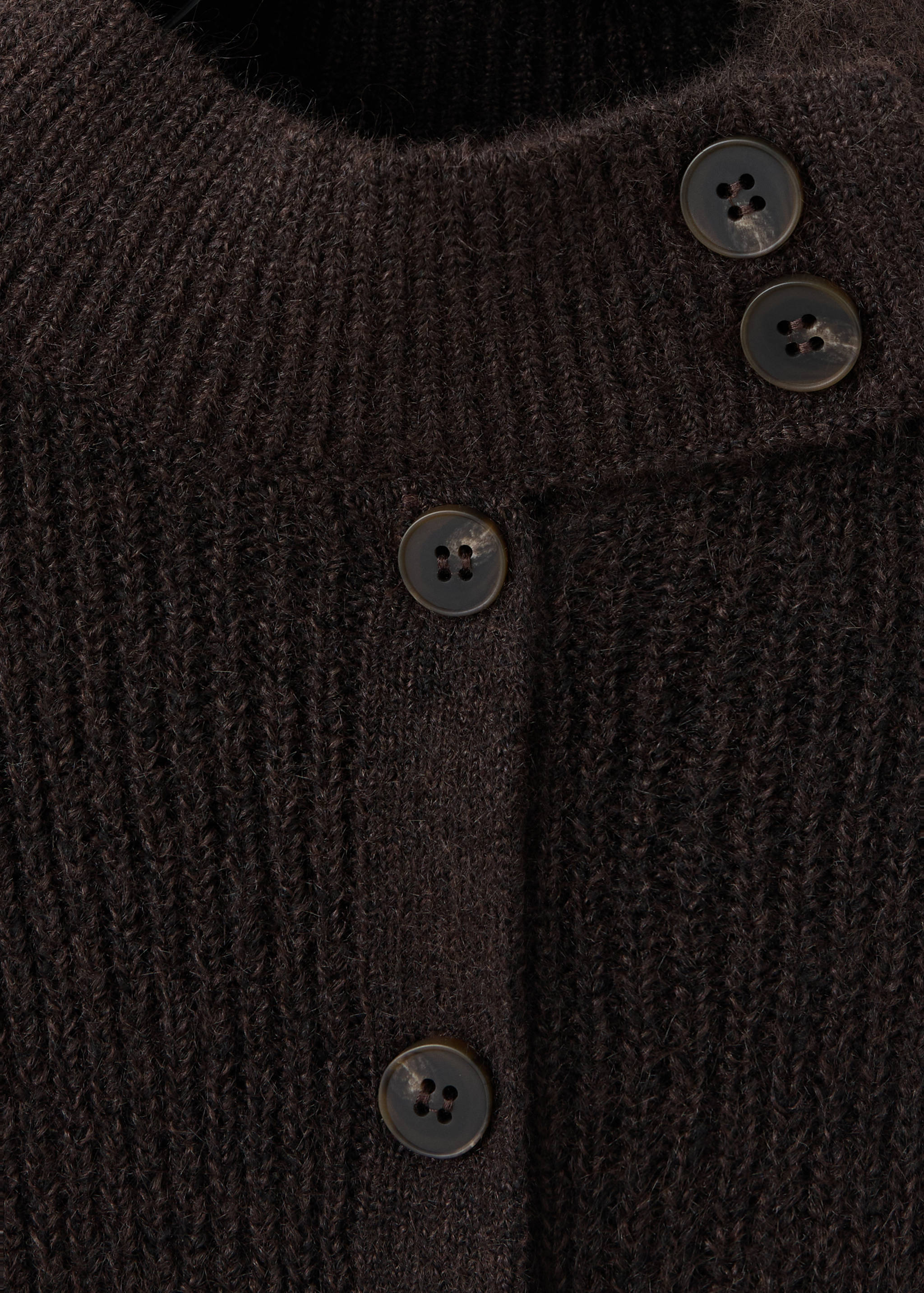 Close-up of a dark brown ribbed knit cardigan with button details.
