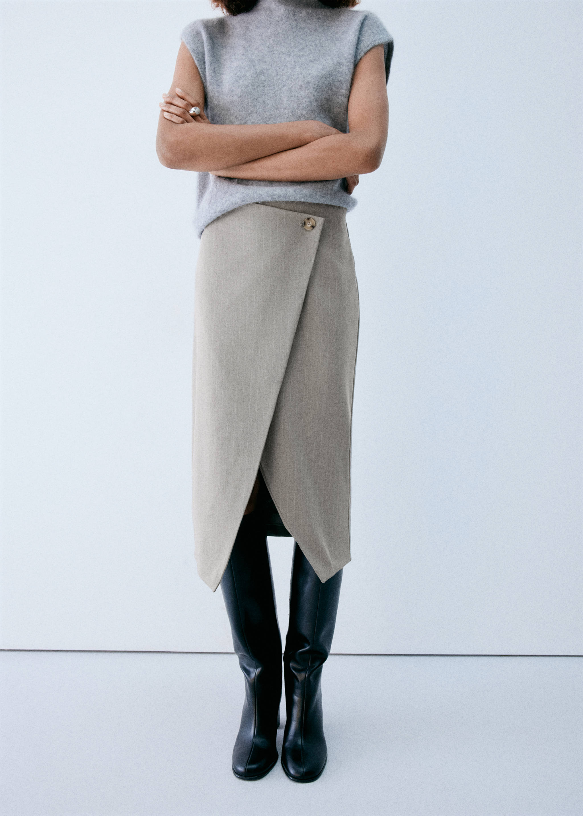 Beige wrap midi skirt with asymmetrical front and button.
