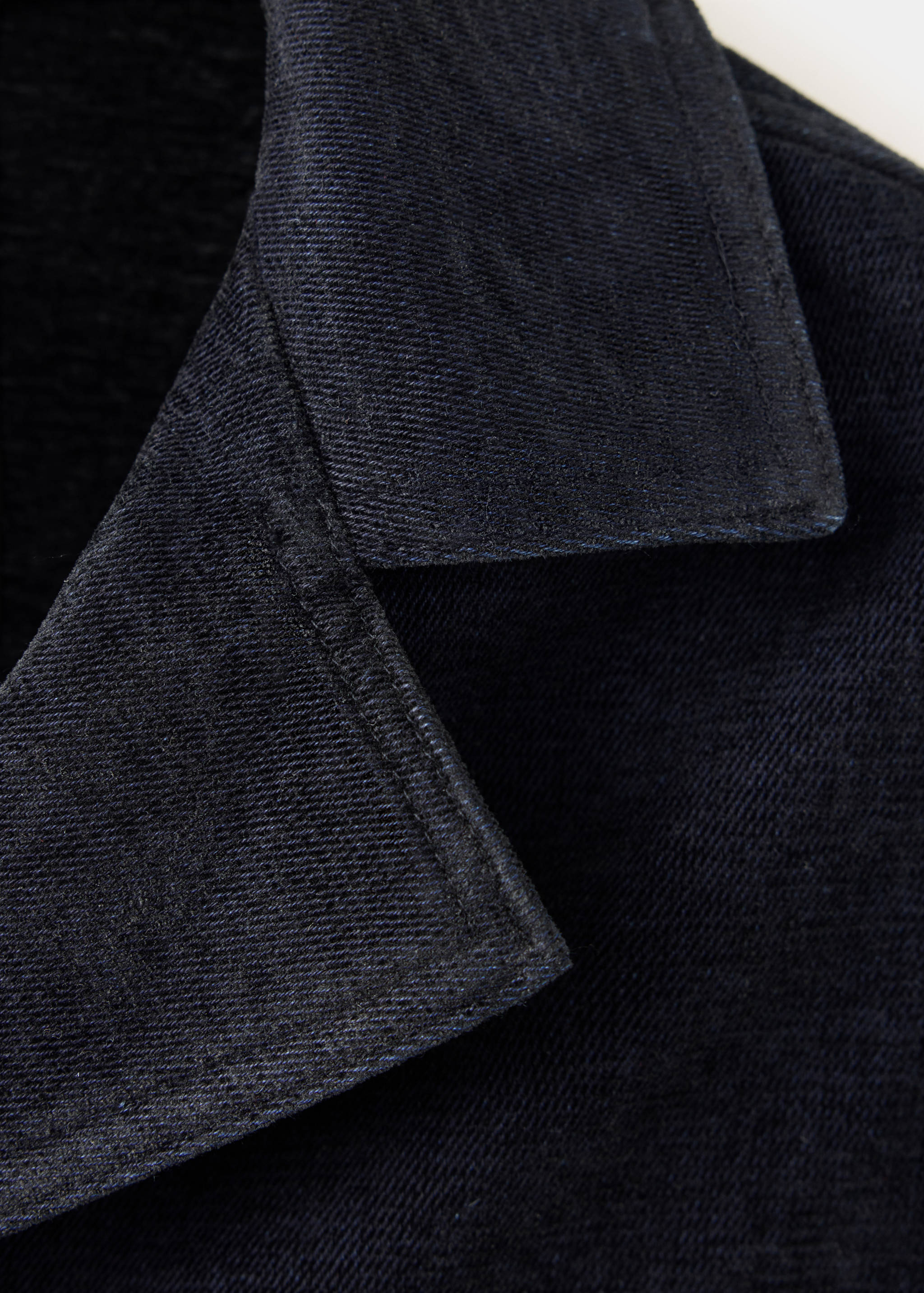 Close-up of a dark navy blue jacket collar and lapel.