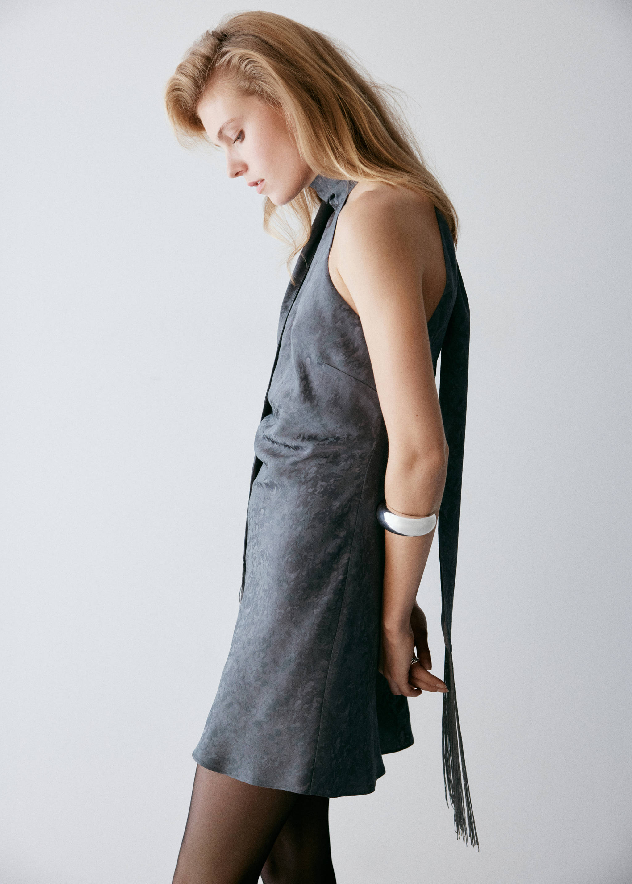 Dark grey sleeveless minidress with a high halter neck and long tie.