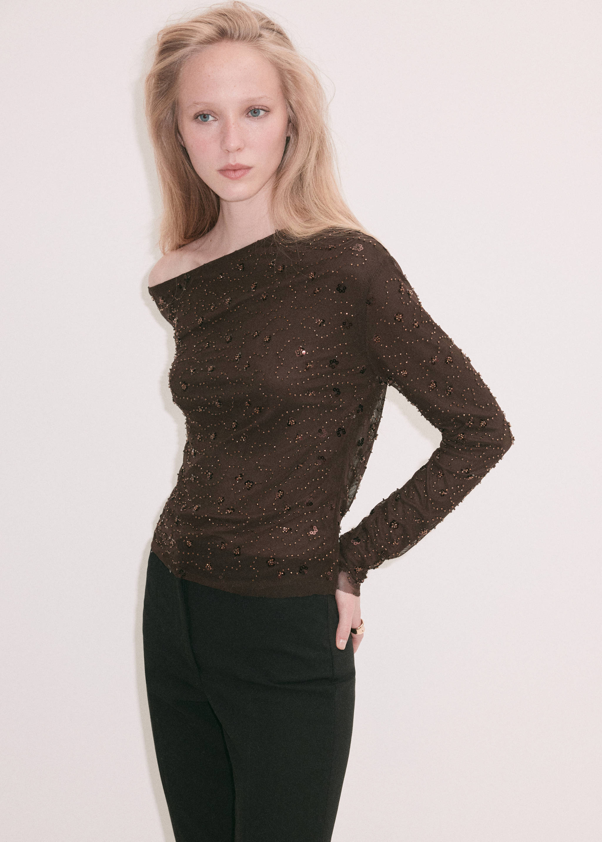 Dark brown beaded asymmetric one-shoulder blouse in sheer mesh fabric.