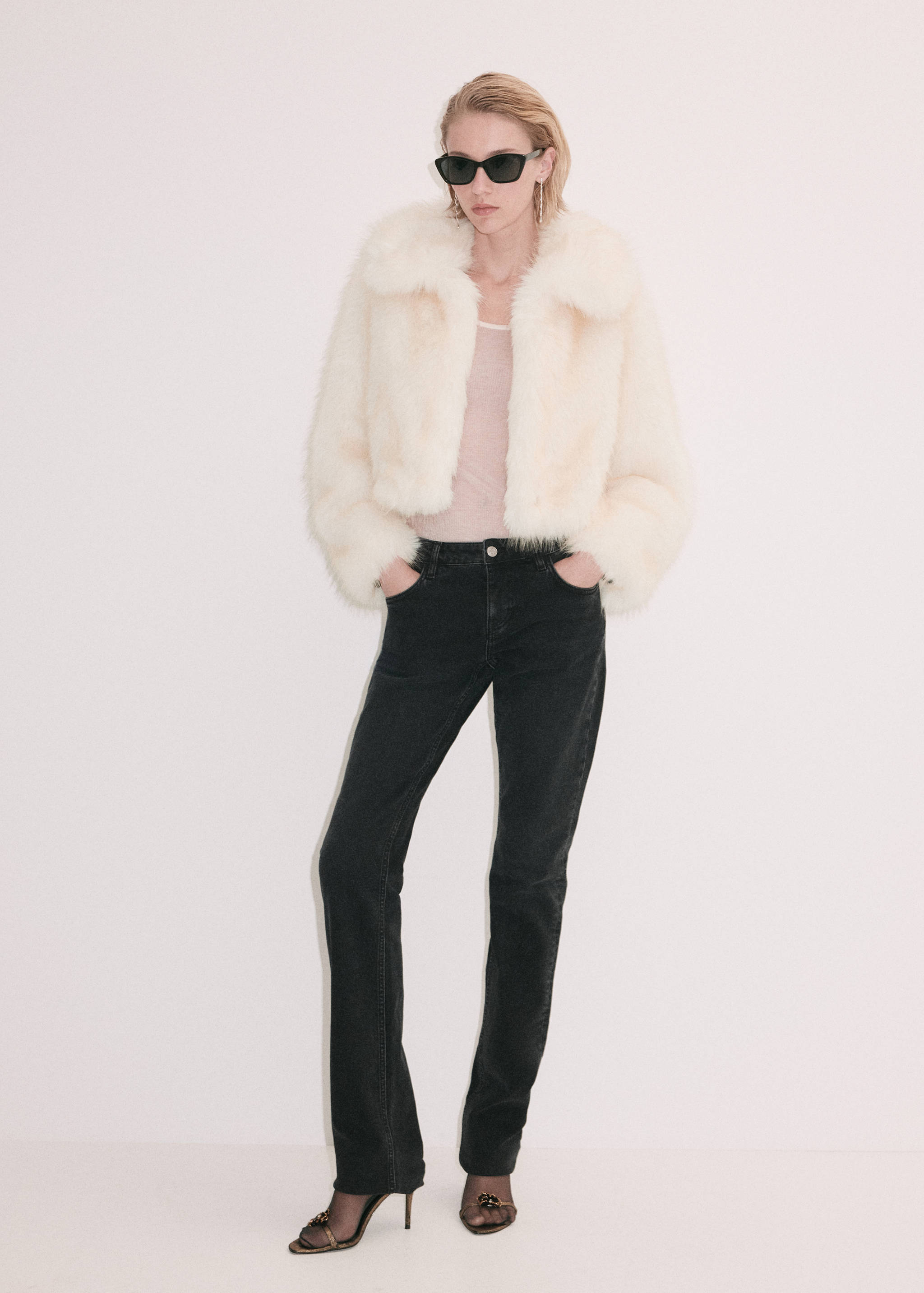 Off-white cropped faux-fur jacket with a wide collar worn with dark jeans.