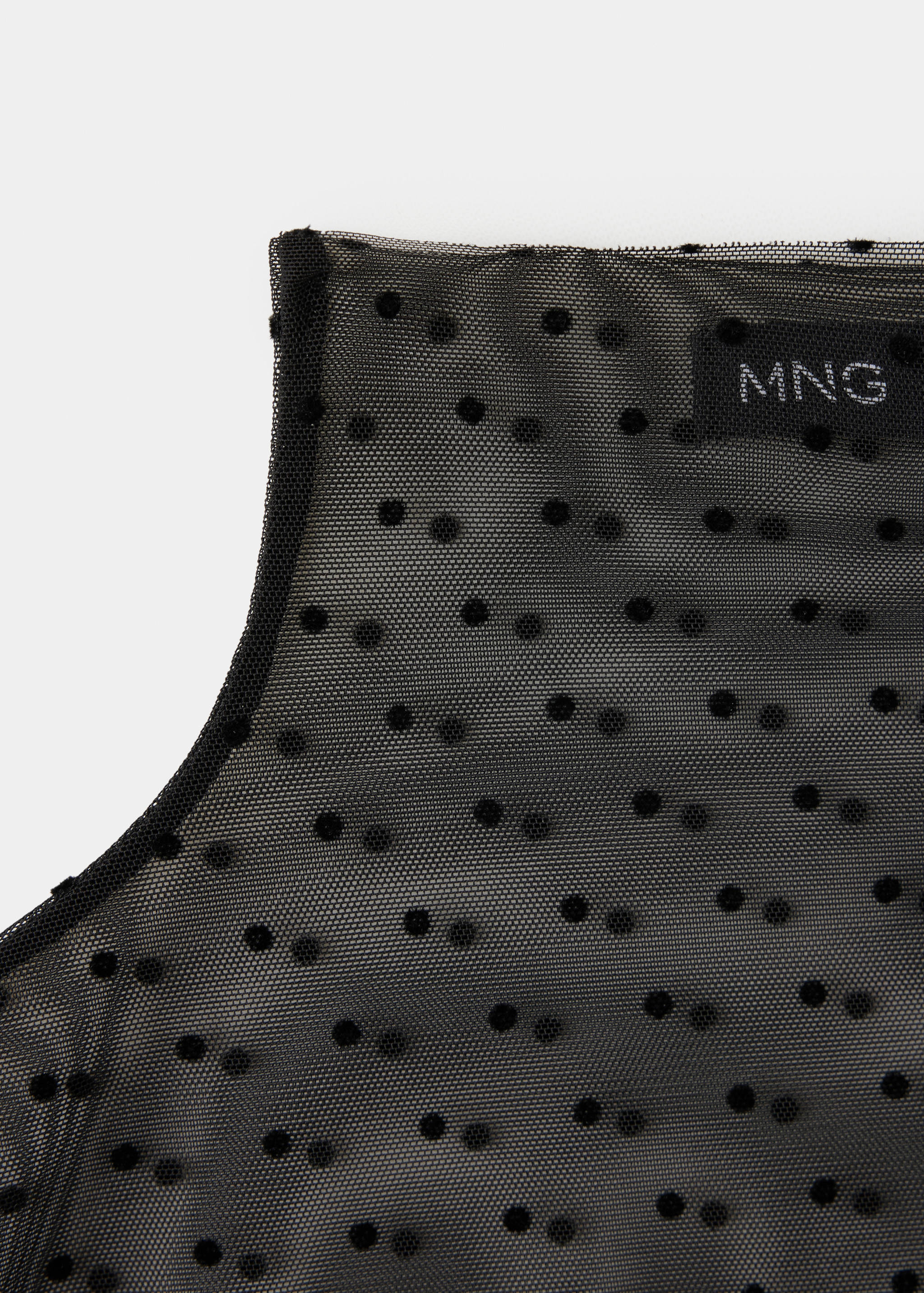 Black sheer mesh blouse detail with flocked polka dots.