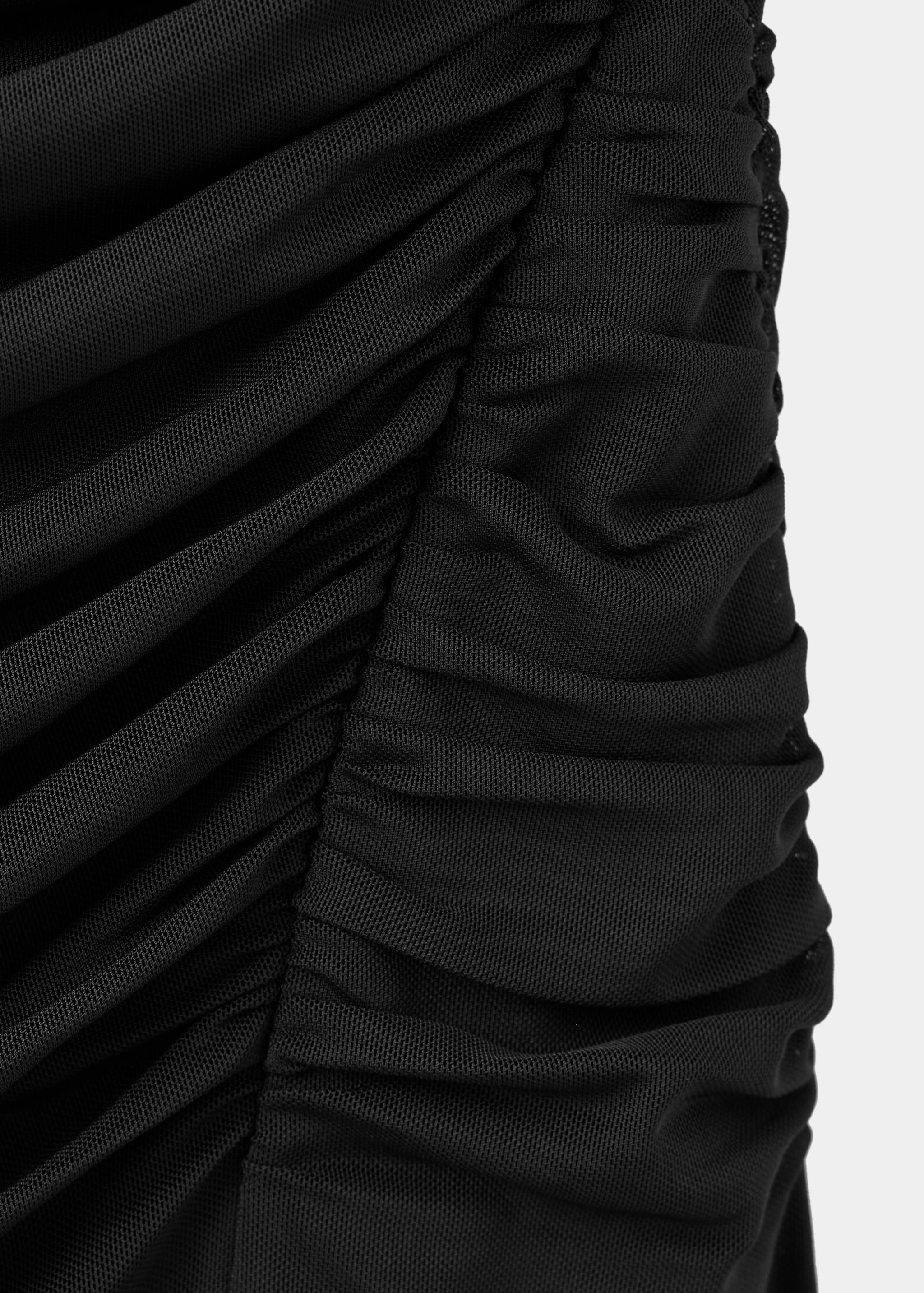 Close-up of the black ruched mesh fabric texture of a dress.