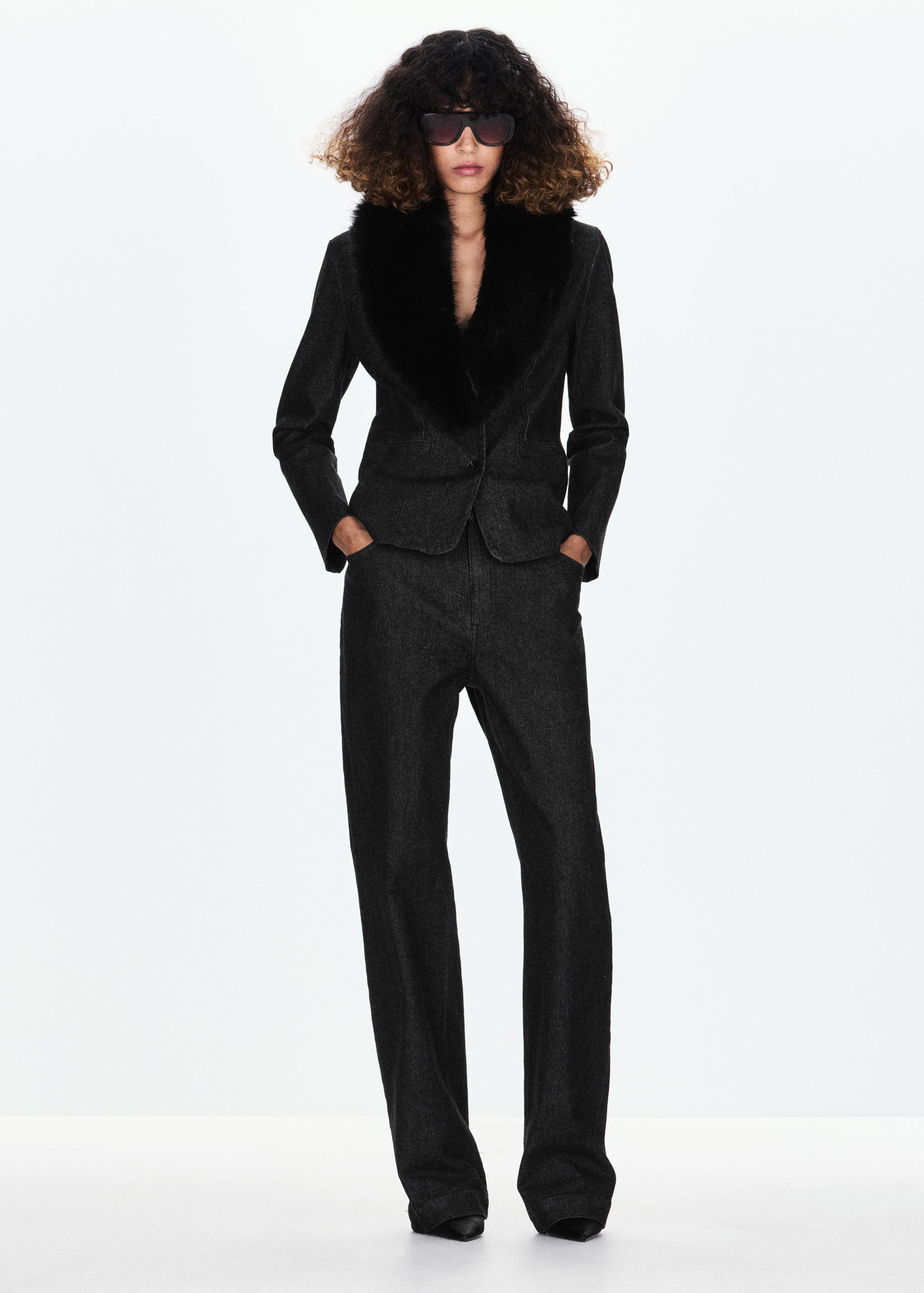 Dark grey blazer with a black faux-fur collar, worn with matching trousers.
