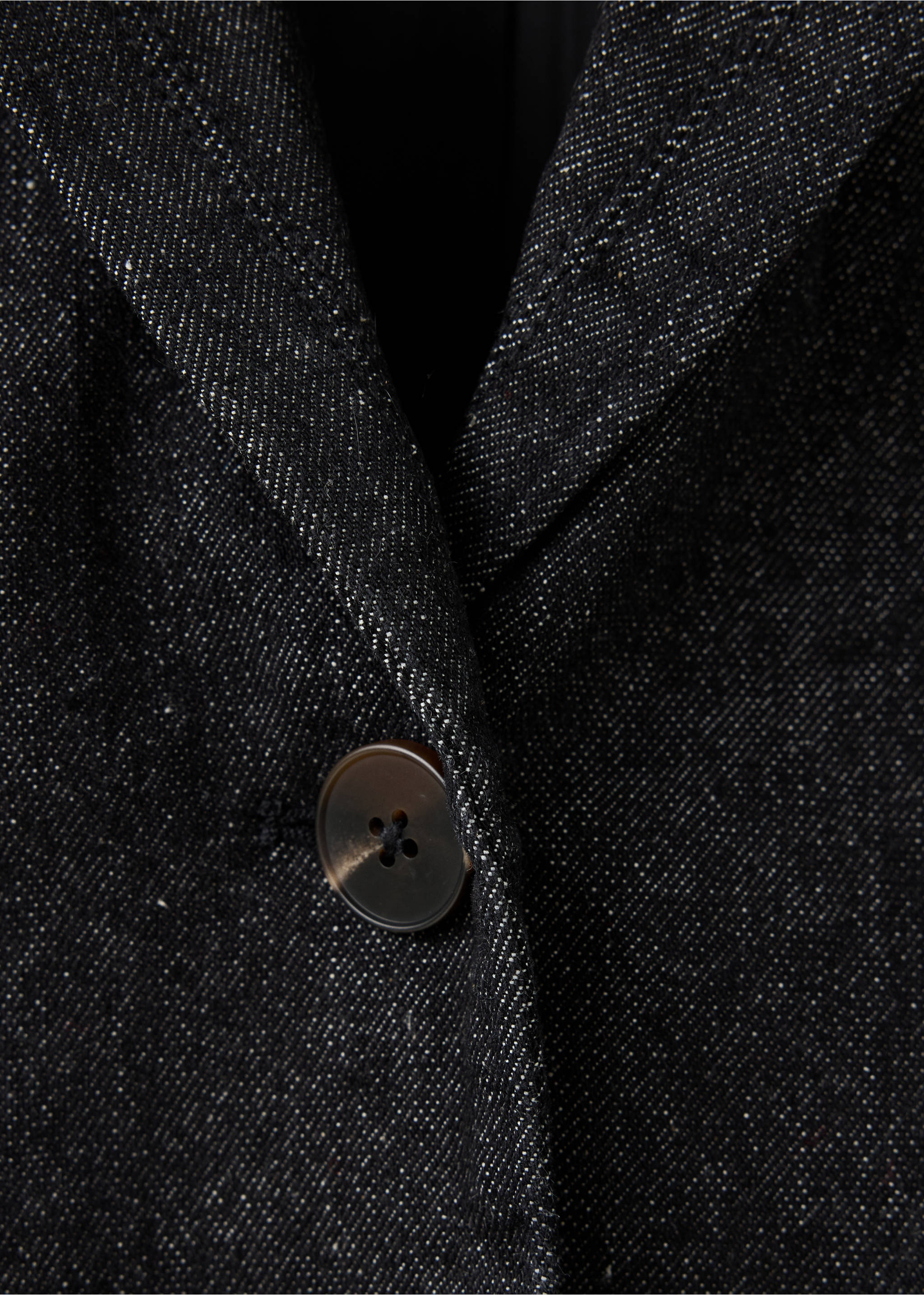 Close-up of a dark grey flecked blazer showing the lapel and button detail., Open Blue. Ref: 37089134-00.