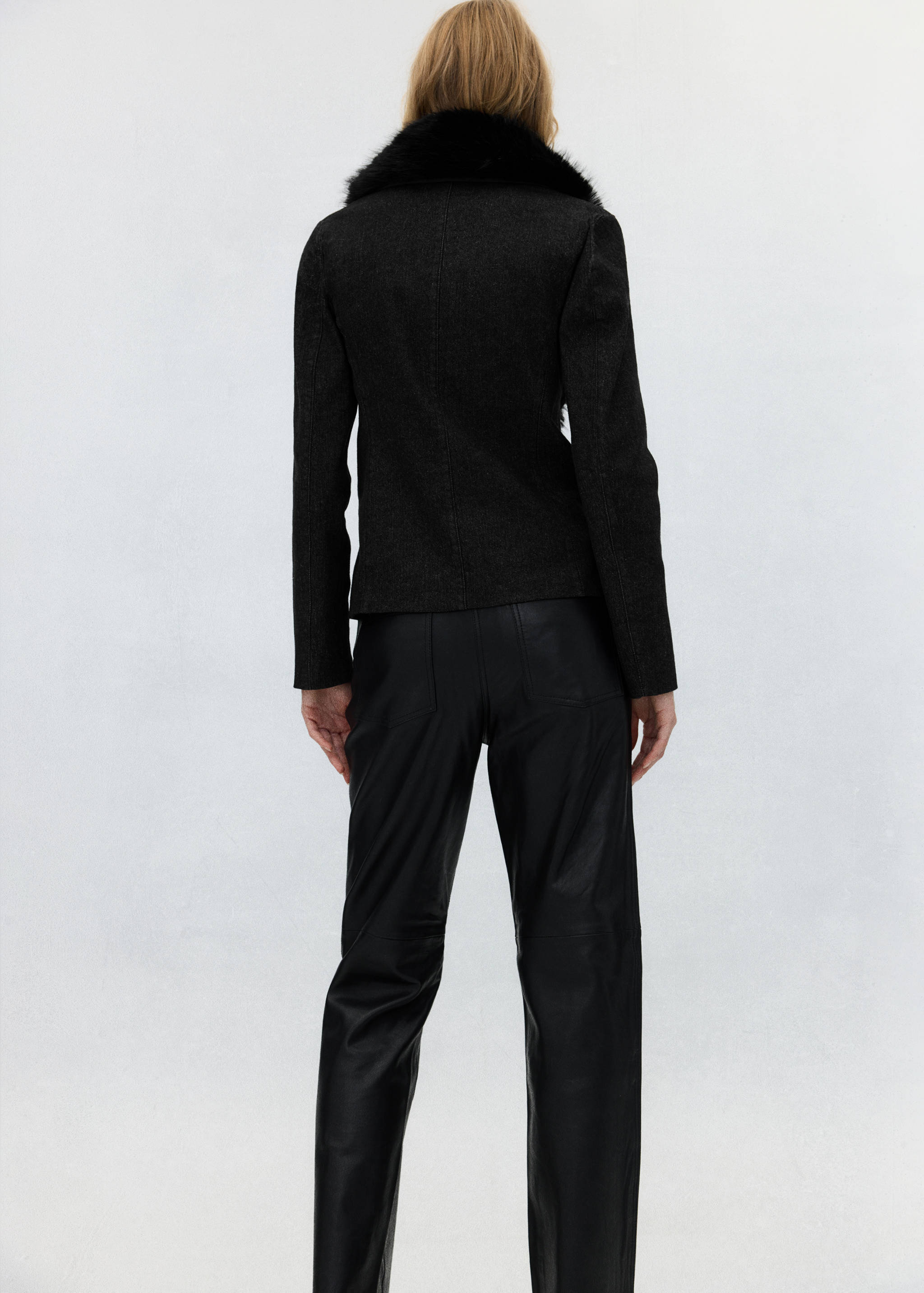 Dark grey blazer with black faux-fur collar, back view