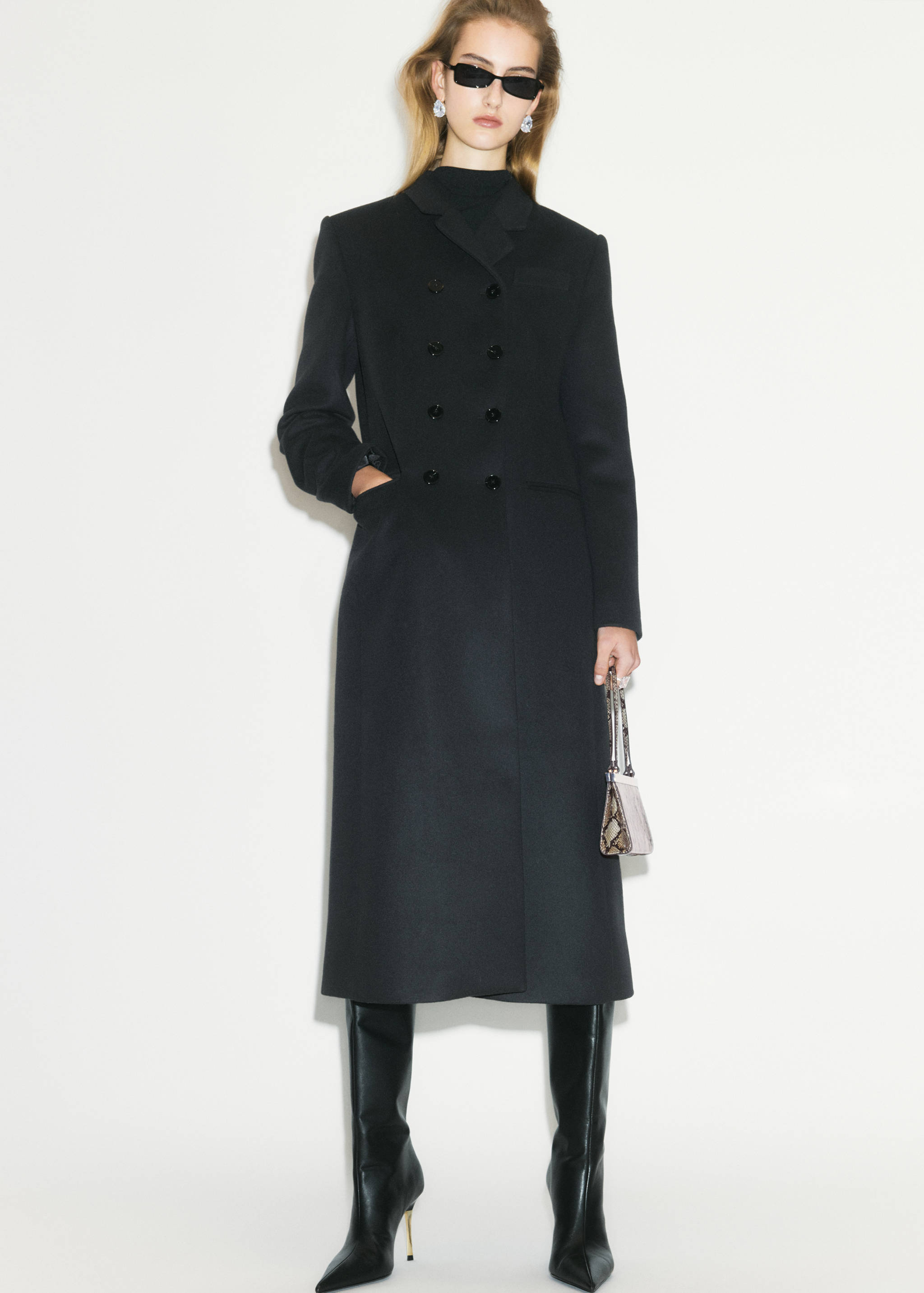 Black leather boots with knee-high shafts and slim gold stiletto heels.