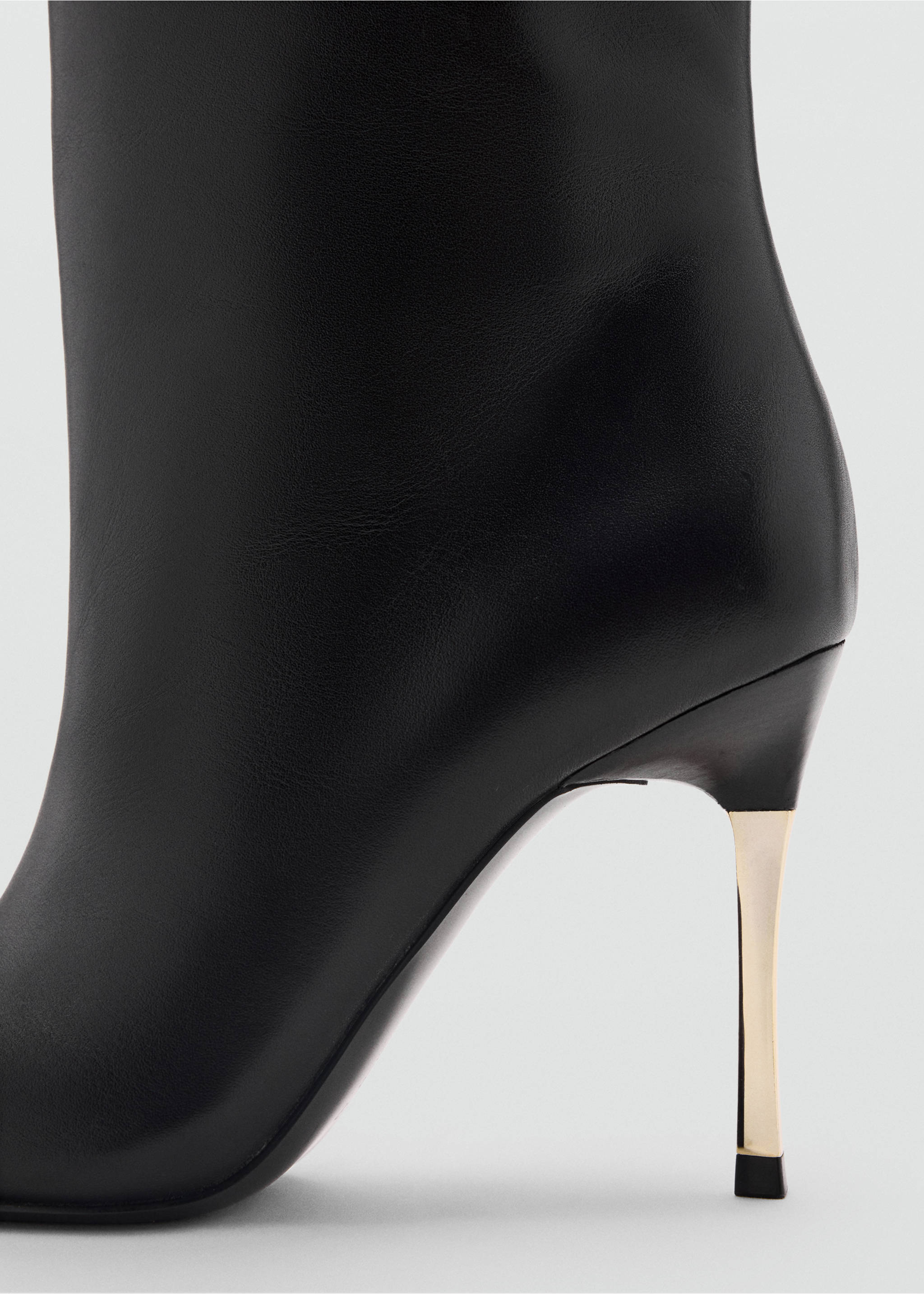 Close-up of a black boot with a gold stiletto heel., Black. Ref: 37089138-00.