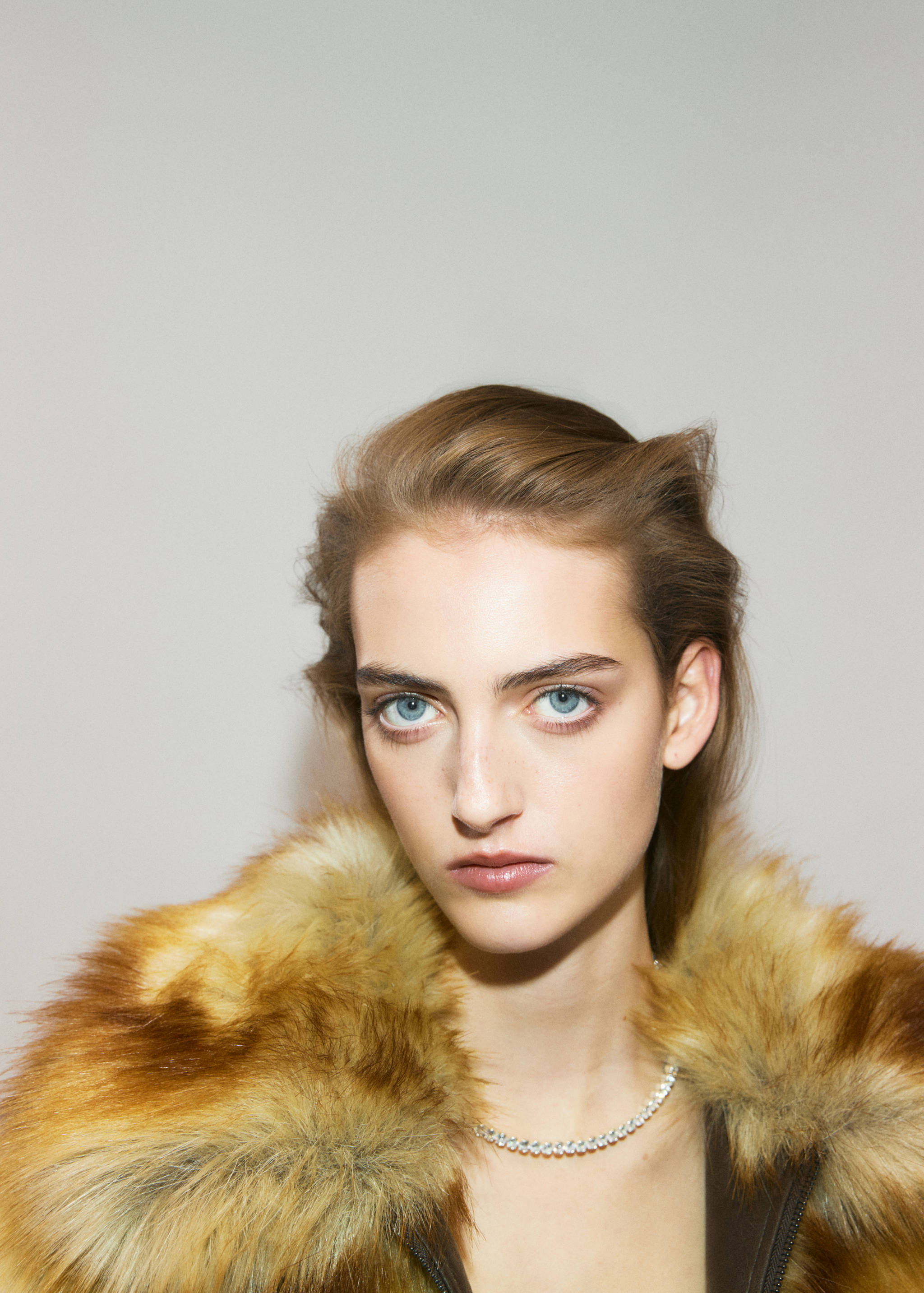 Brown faux-fur collar worn with a rhinestone choker necklace.