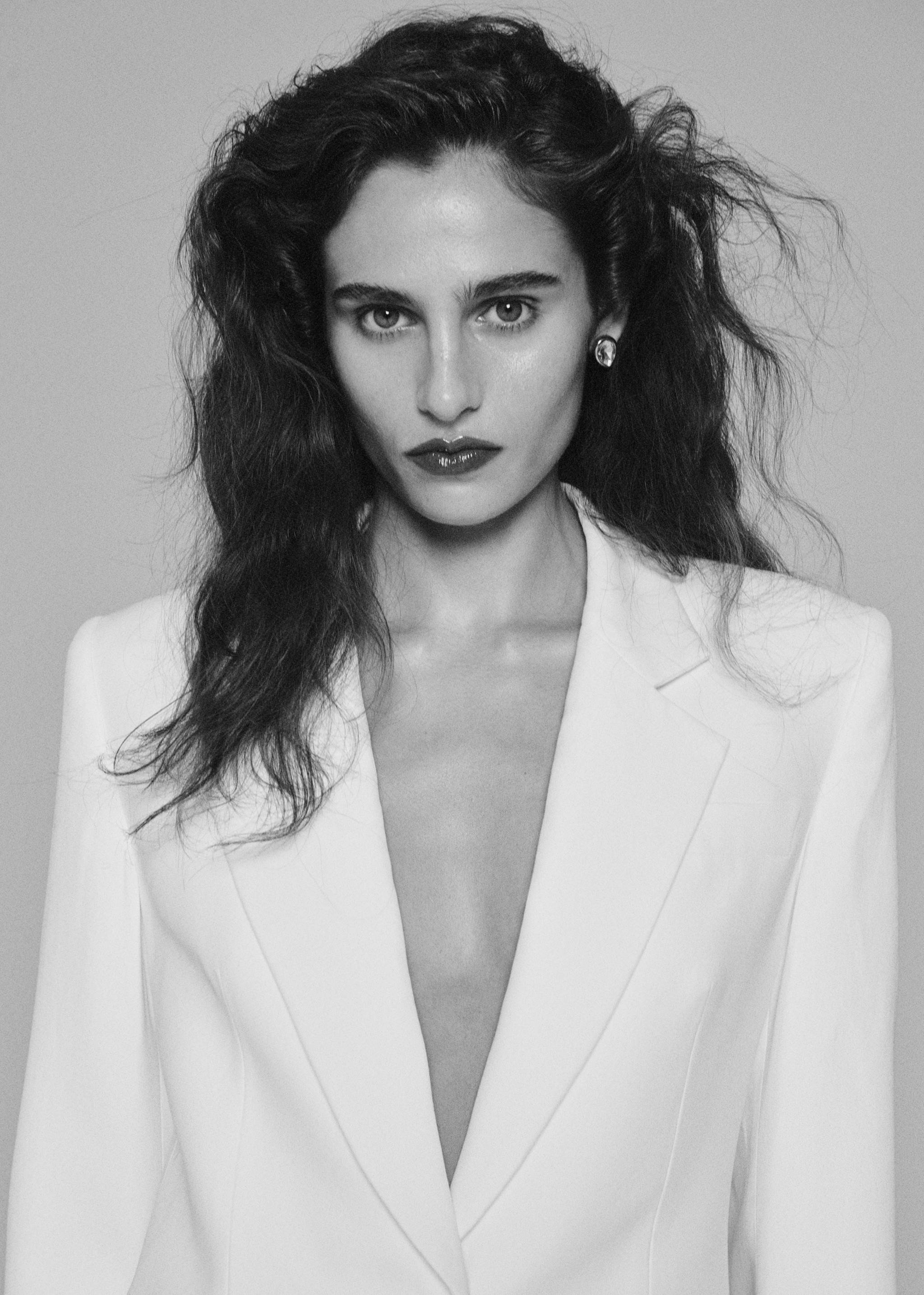 Close-up portrait of a model wearing a white dress with a deep V-neck., White. Ref: 37089142-00.