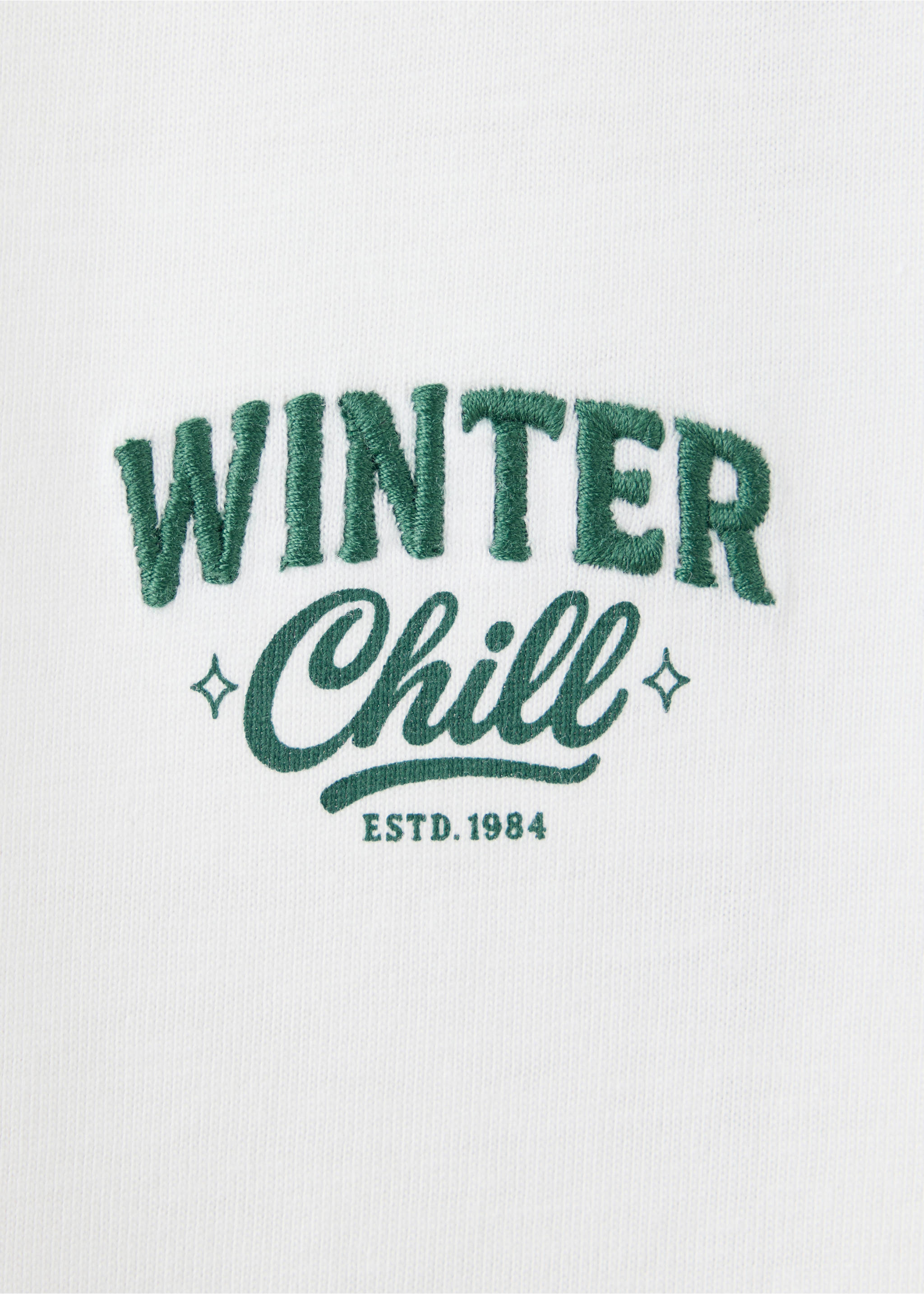 Close-up of a white pyjama top with green 'Winter Chill' embroidery., Dark Green. Ref: 37089213-00.