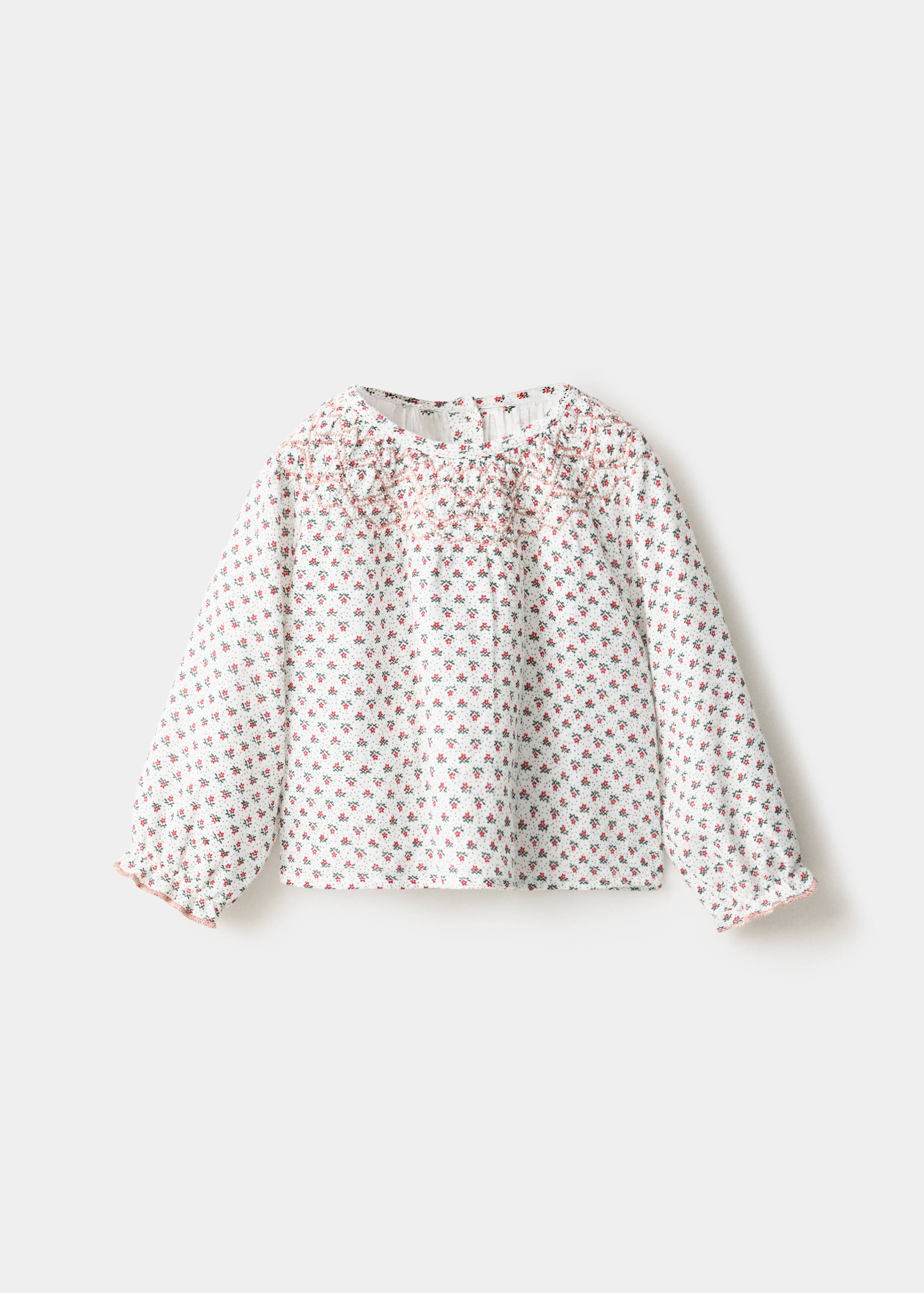 White kids' floral long-sleeve blouse with pink smocked embroidery.