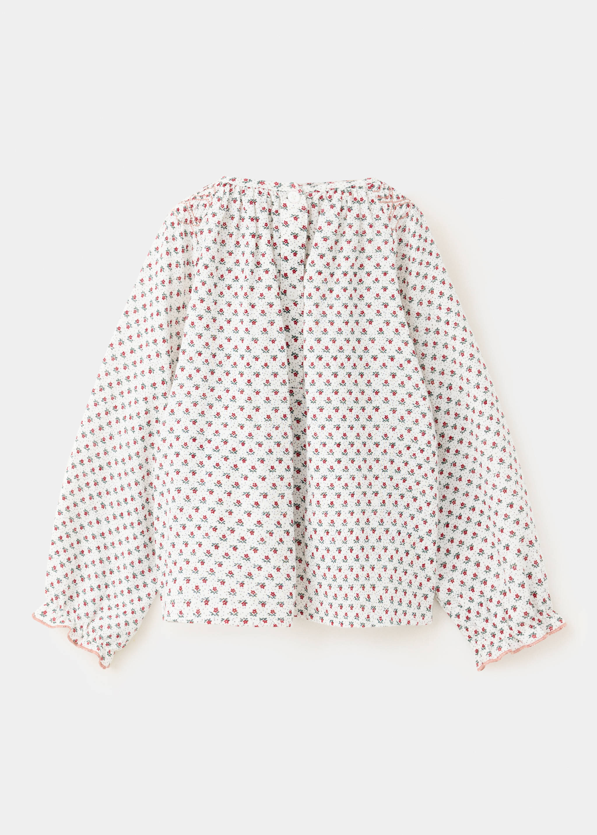 Kids' floral print blouse in white with long ruffled cuffs and smocked back.
