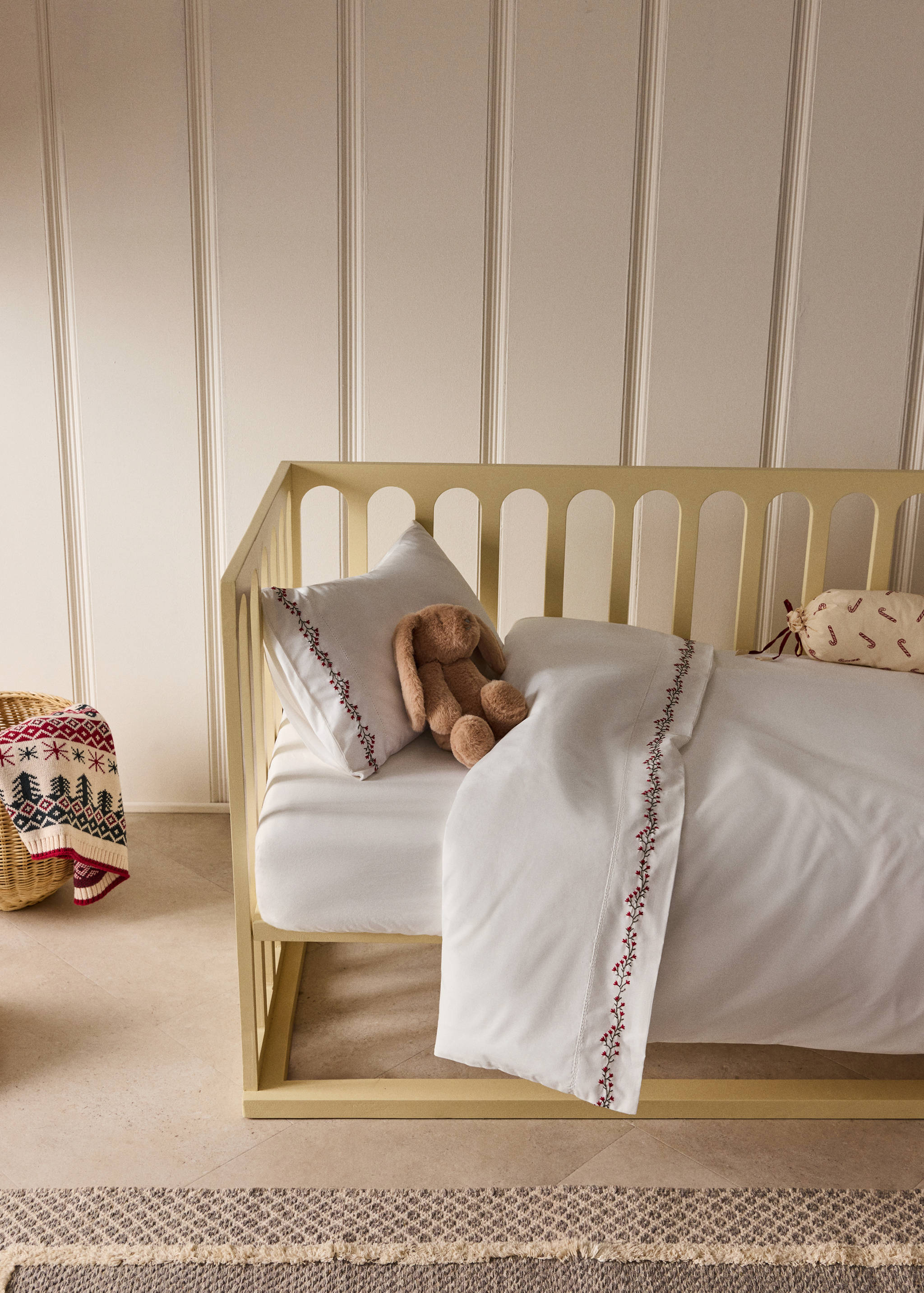 White cot duvet cover with red embroidered berry detail.