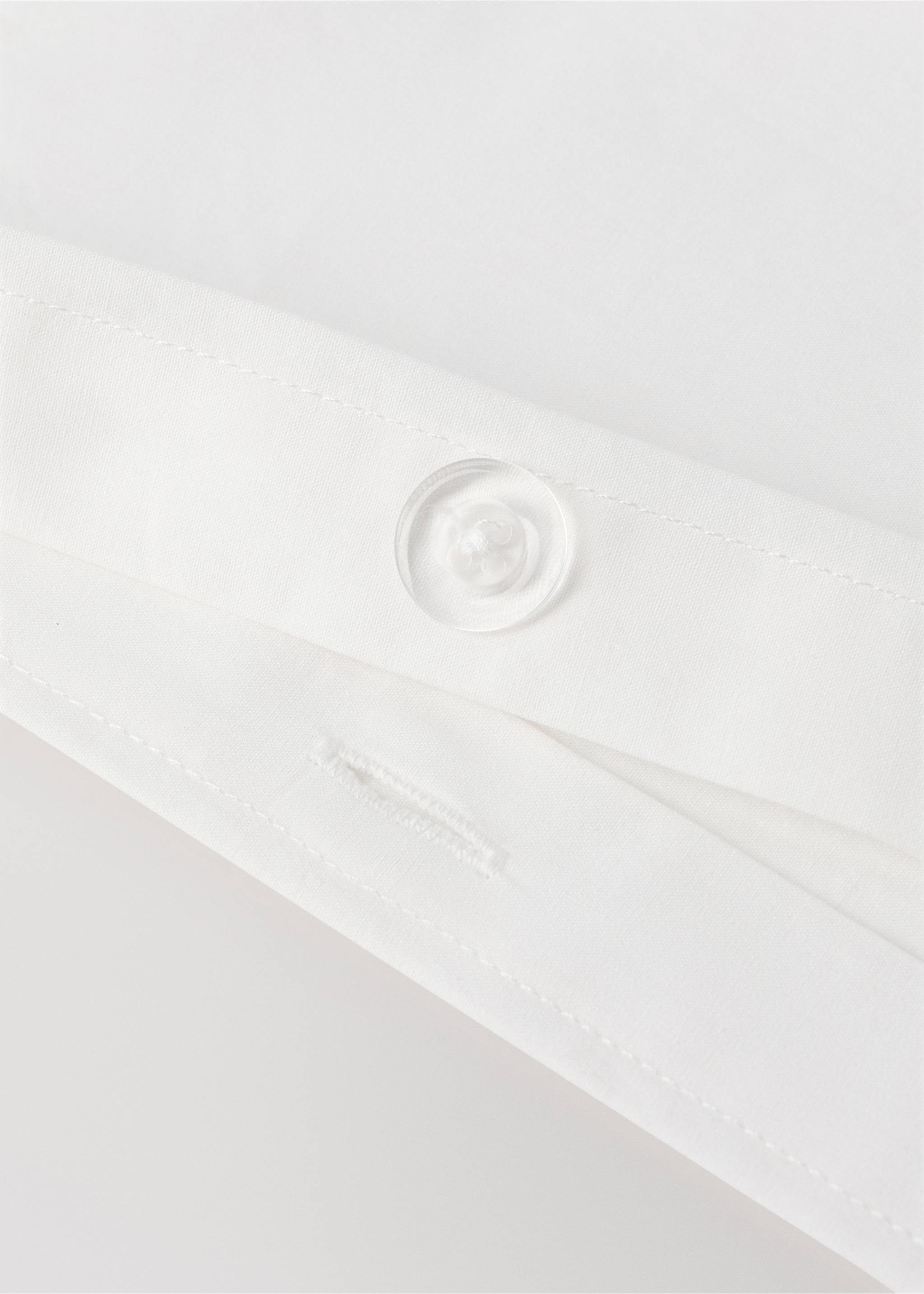 White cot duvet cover detail showing a button closure., Off White. Ref: 37091542-00.