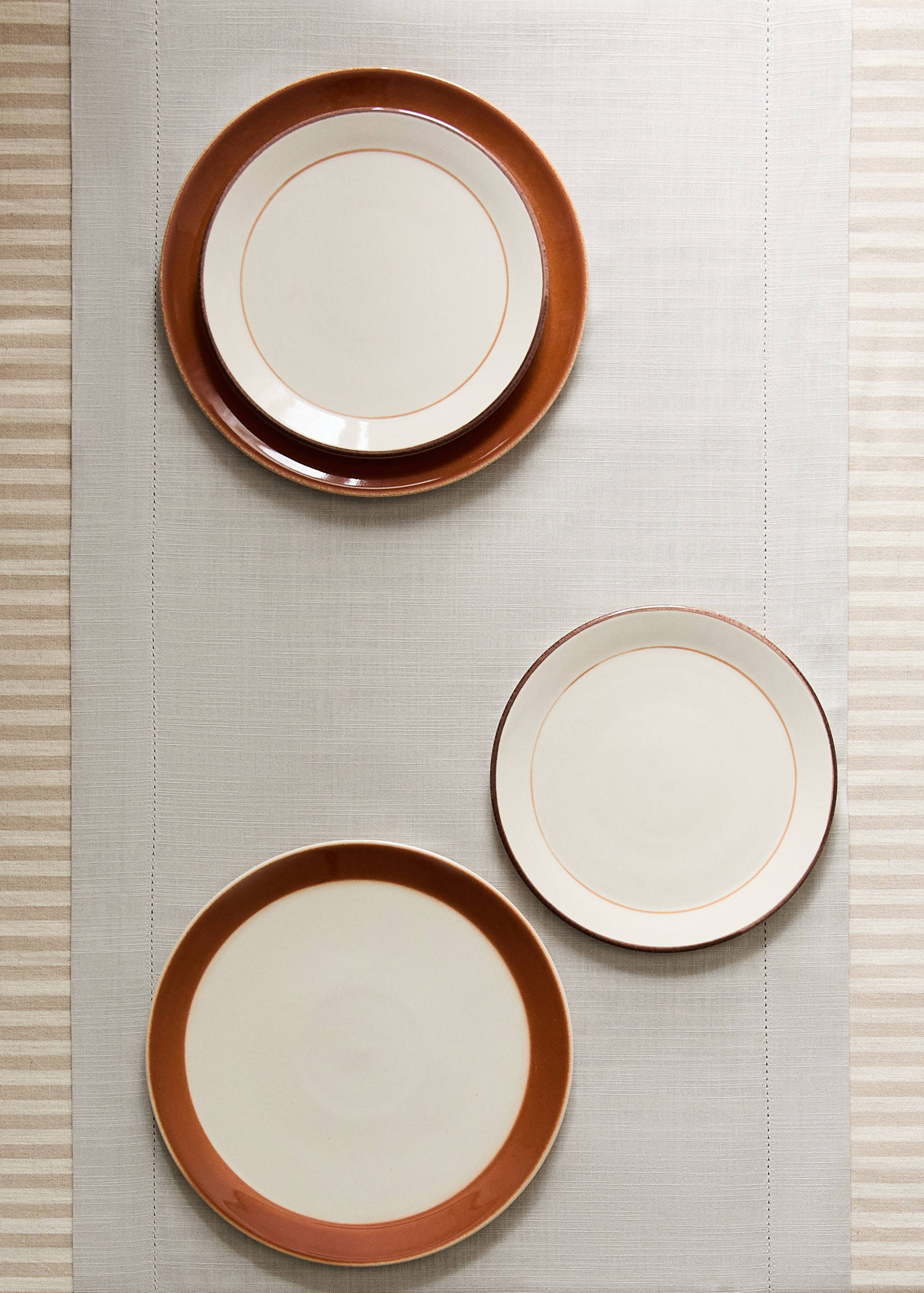 Light-coloured fabric table runner with a hemstitch border, displayed with ceramic plates.