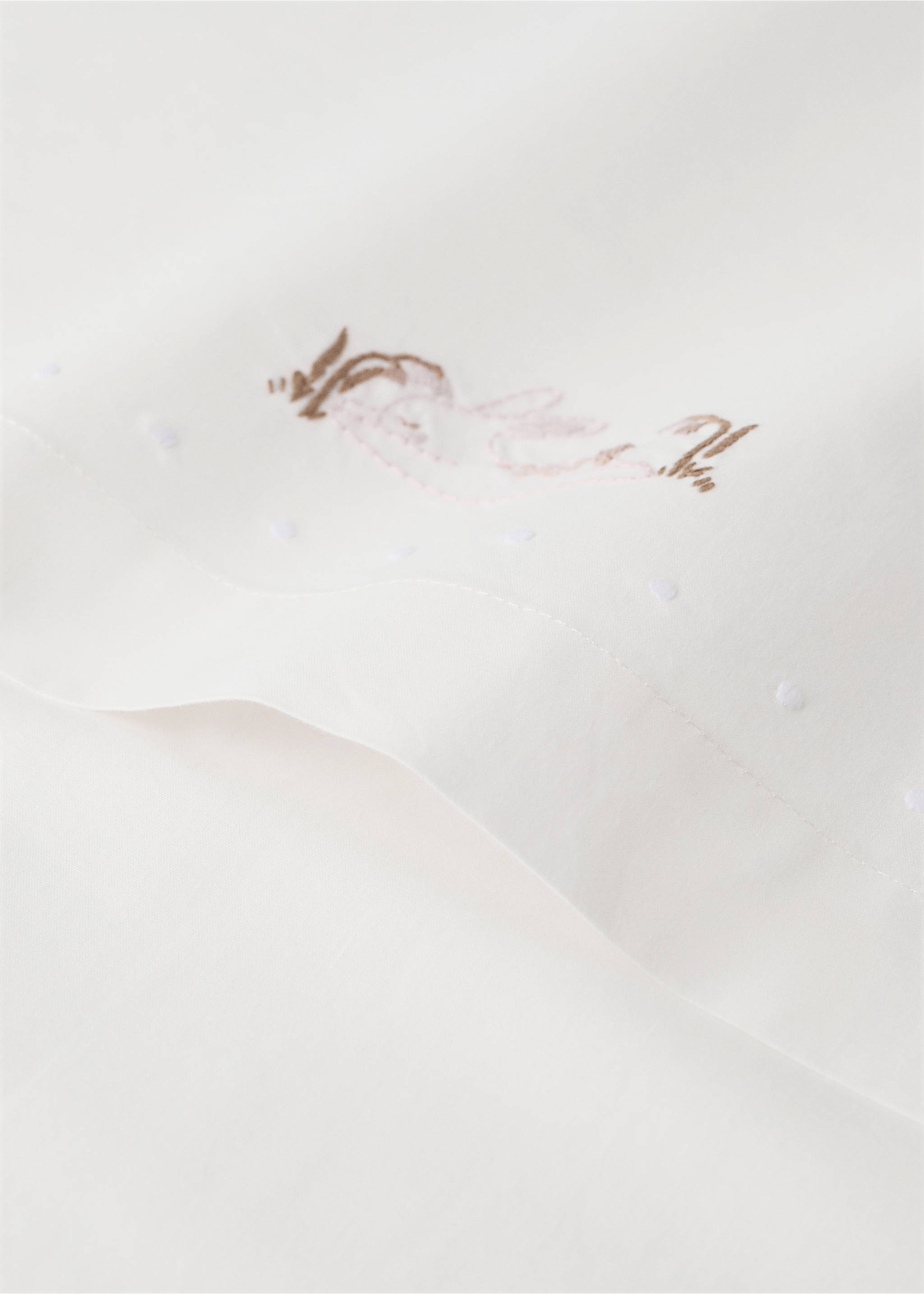 Close-up of an off-white baby sheet with embroidered rabbit detail., Medium Brown. Ref: 37092558-00.