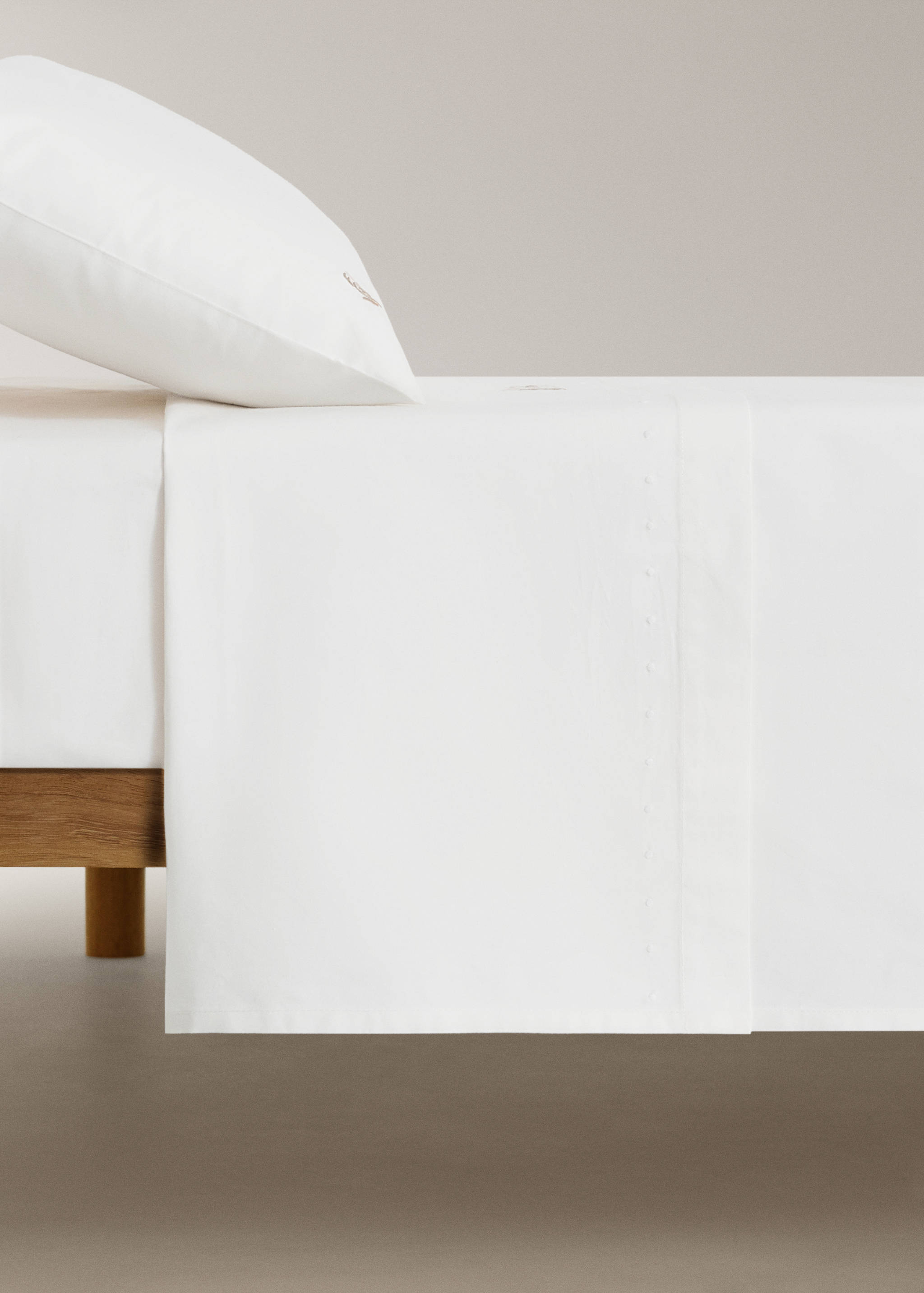 White baby bed sheet with delicate embroidery.