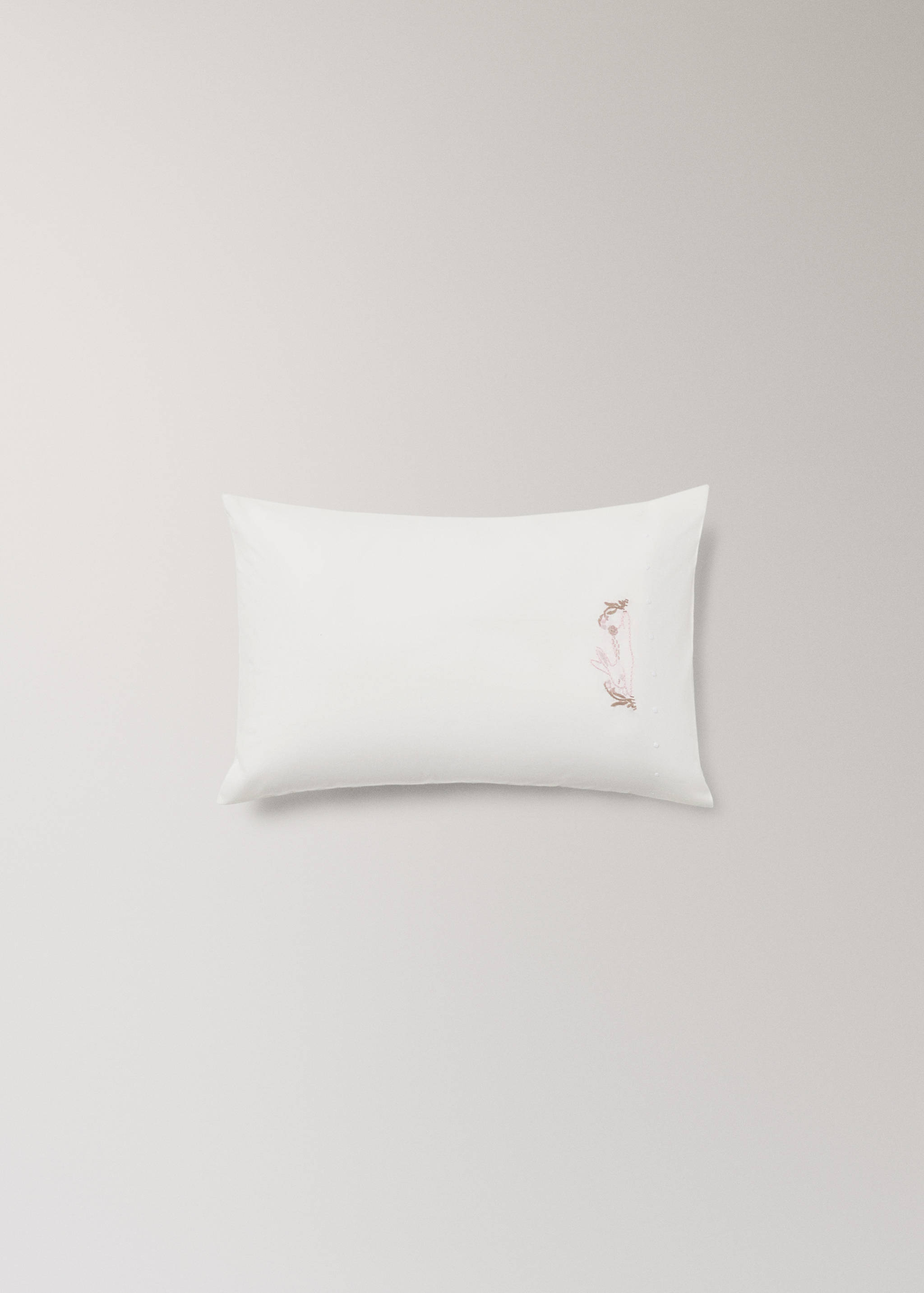 White bedding set pillowcase with delicate embroidery detail.
