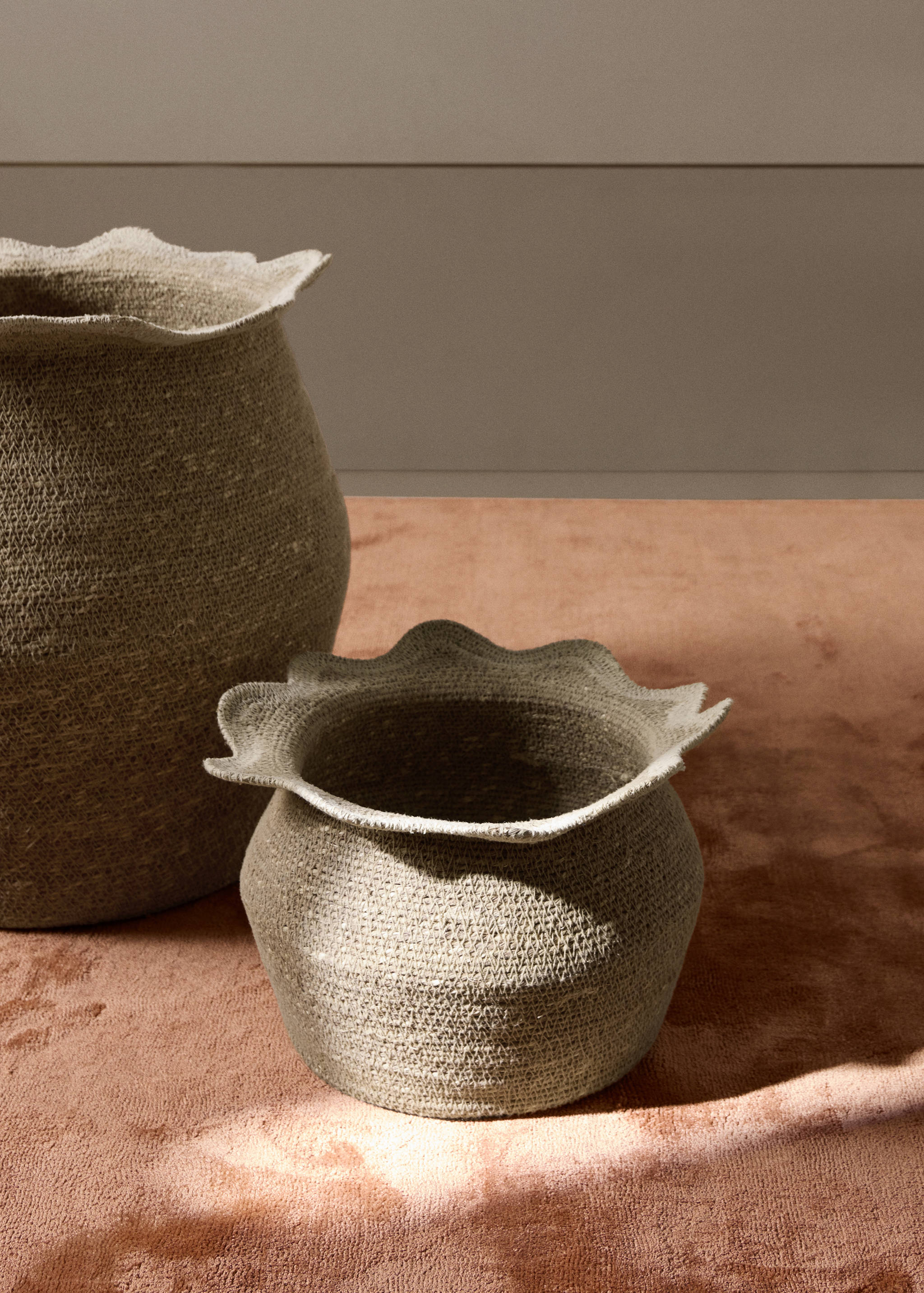 Round woven beige basket with a scalloped rim.