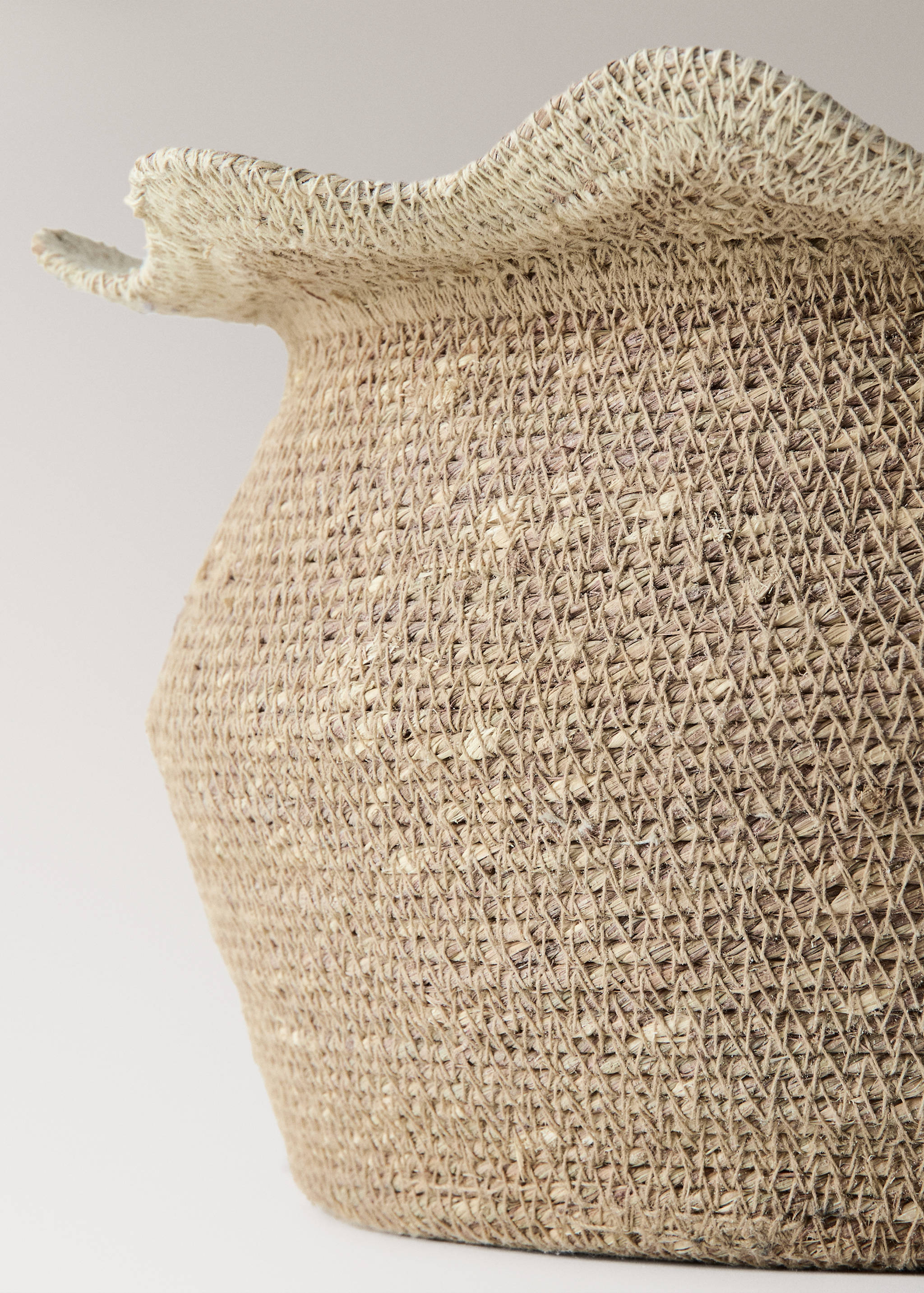 Close-up of a natural woven basket detail with a ruffled rim.
