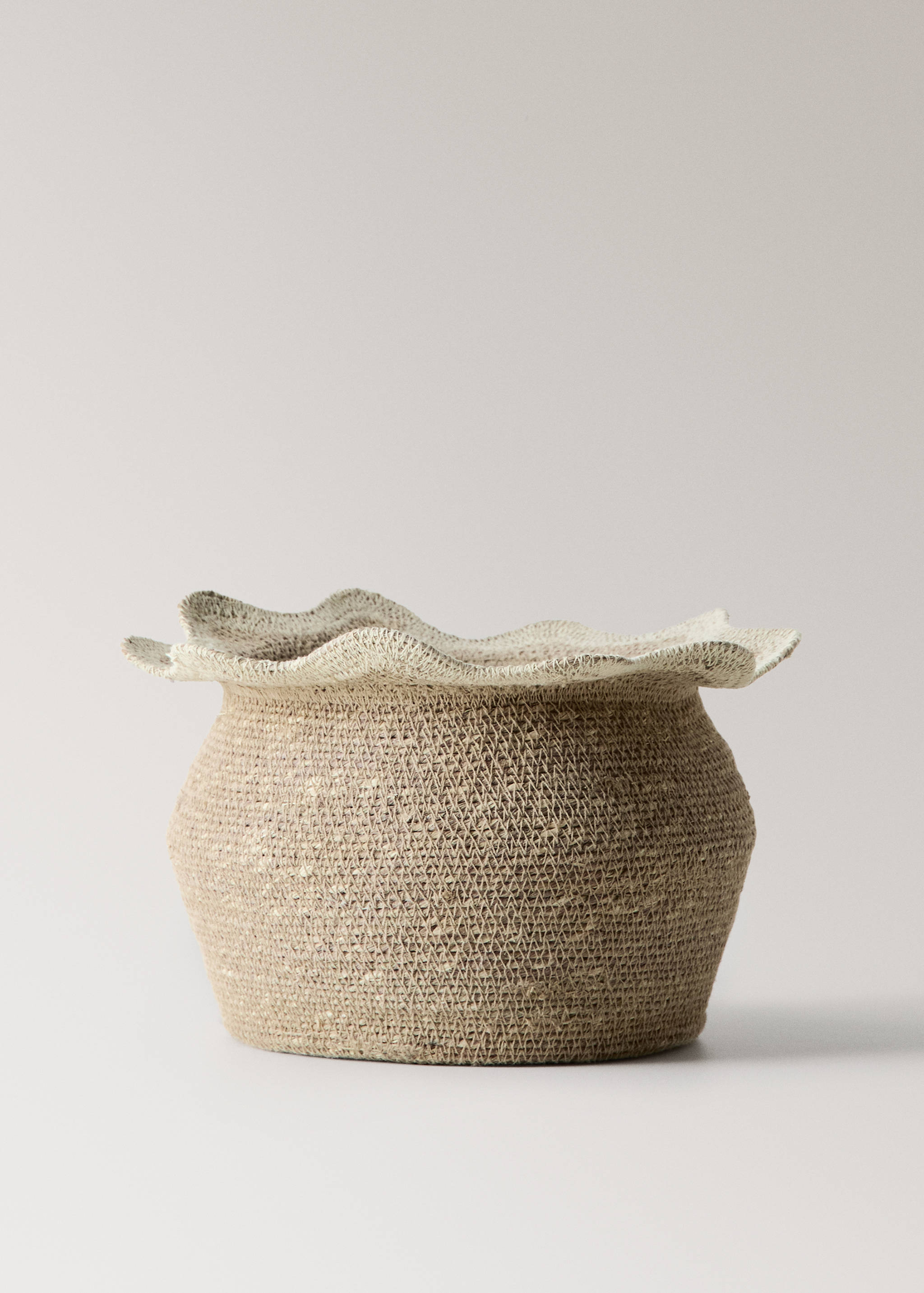 Natural woven basket with a wide ruffled cream rim.