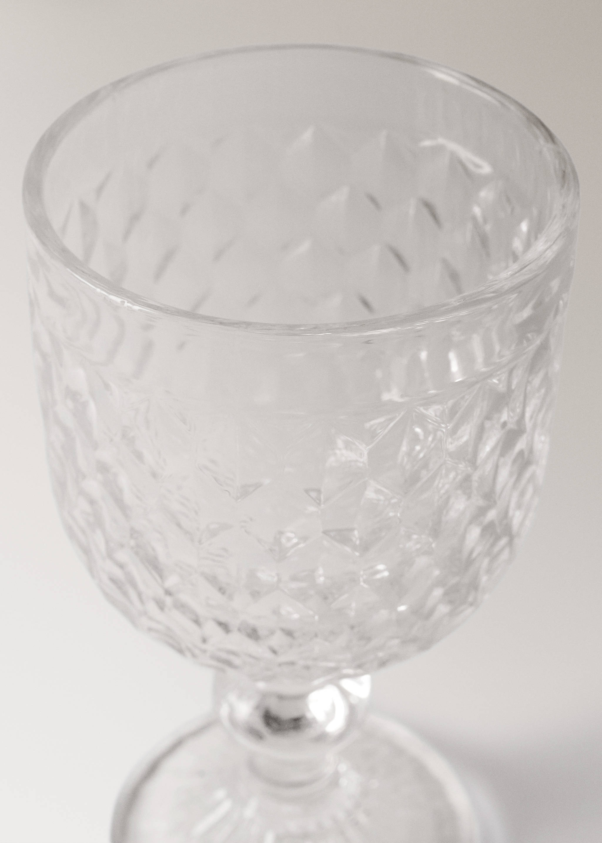 Clear glass goblet with a faceted textured bowl.